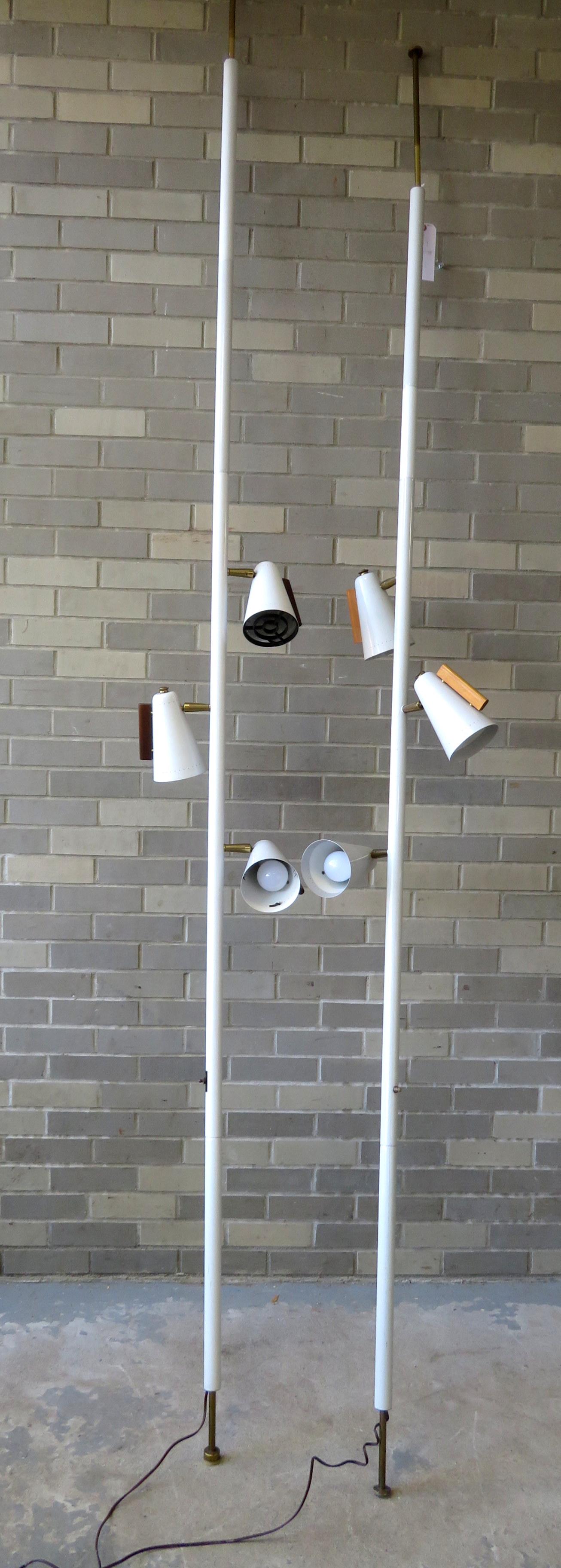 Two Stiffel tension pole floor lamps with 3 white cone: Two Stiffel tension pole floor lamps with 3 white cone shaped lights each, circa 1950-60. Comes in 4 sections for adjusting the height to over 10"H. One tension pin is slightly bent, otherwise both in