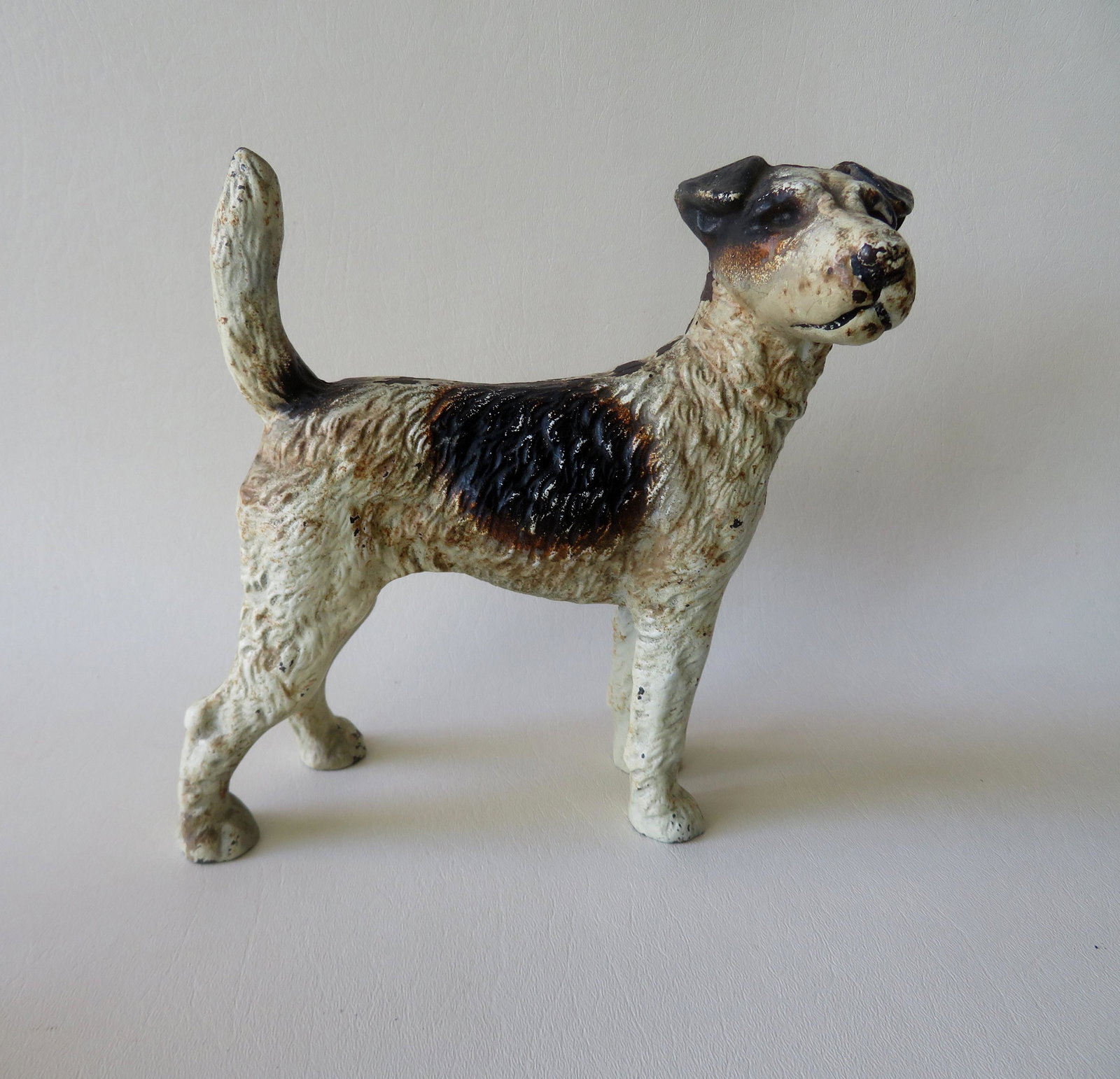 Cast iron Fox Terrier dog door stop in original paint,: Cast iron Fox Terrier dog door stop in original paint, late 19th century. Very good condition. 8"H x 8 1/4"W.
