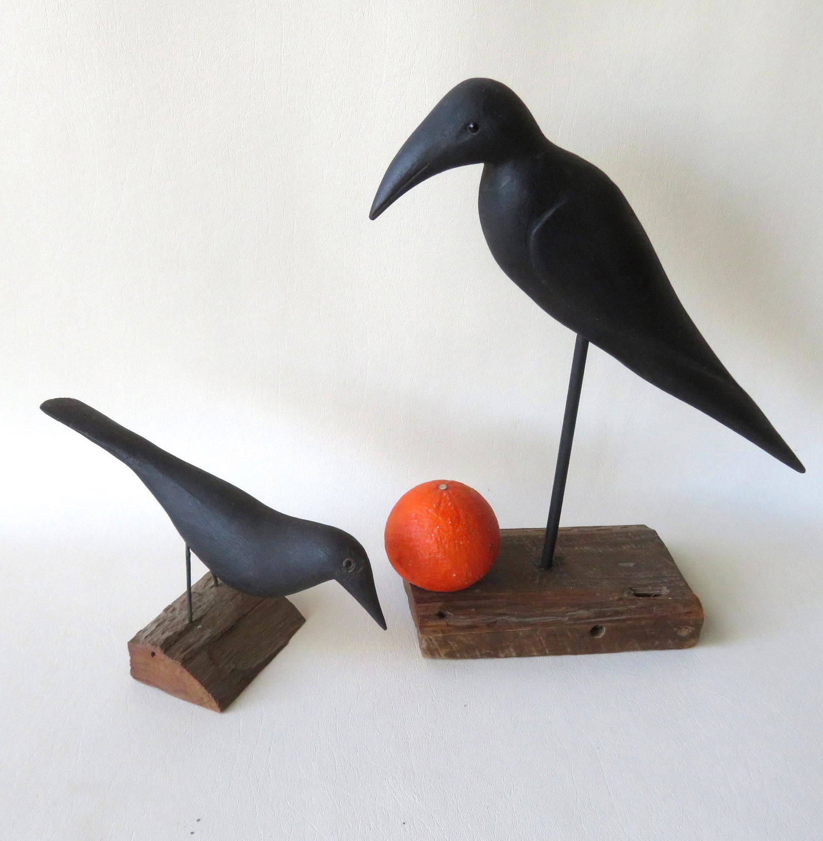 Two carved crow decoys, both with glass eyes and: Two carved crow decoys, both with glass eyes and mounted on stands. One signed Will Kirkpatrick, the other appears to be signed Bayea J. Beck. The largest 14"L x 12"H on stand.