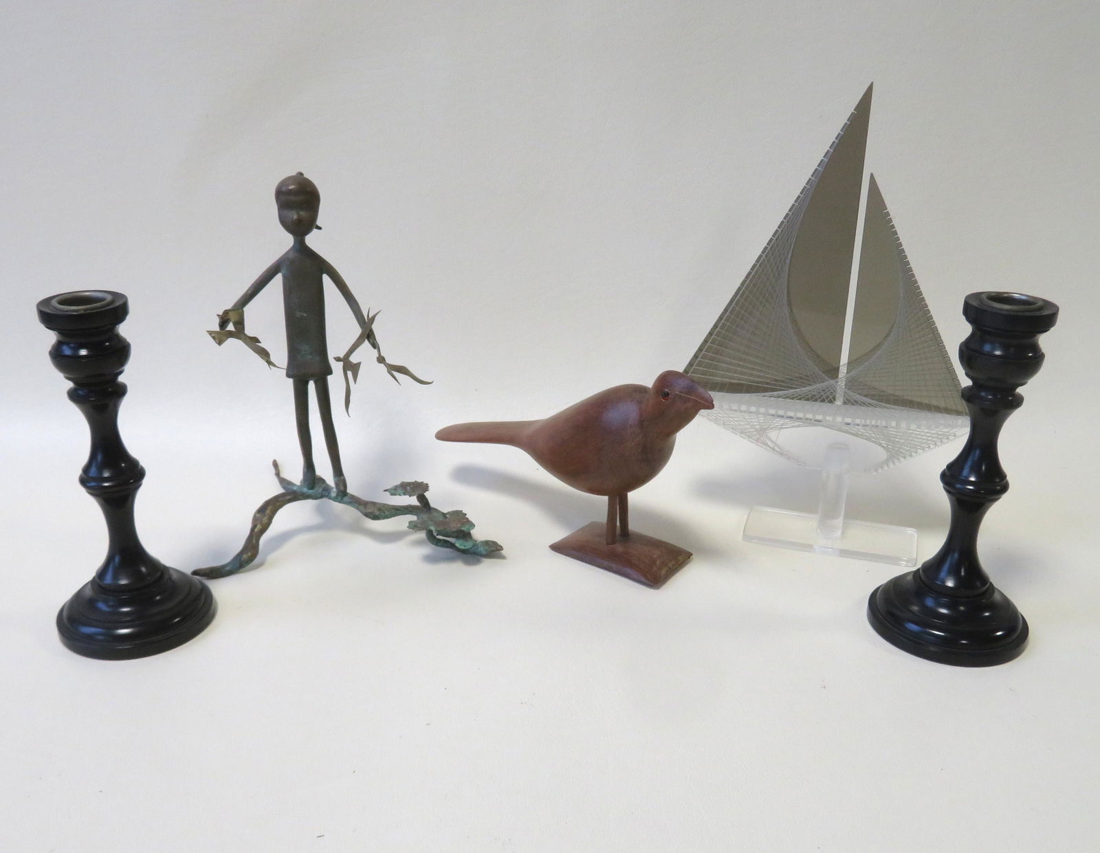 Grouping of 5 mid century collectibles including: A: Grouping of 5 mid century collectibles including: A carved stylized bird, a celluloid sail boat, a pair of ebony candlesticks, and a small gilt bronze sculpture of a young girl holding birds - appears