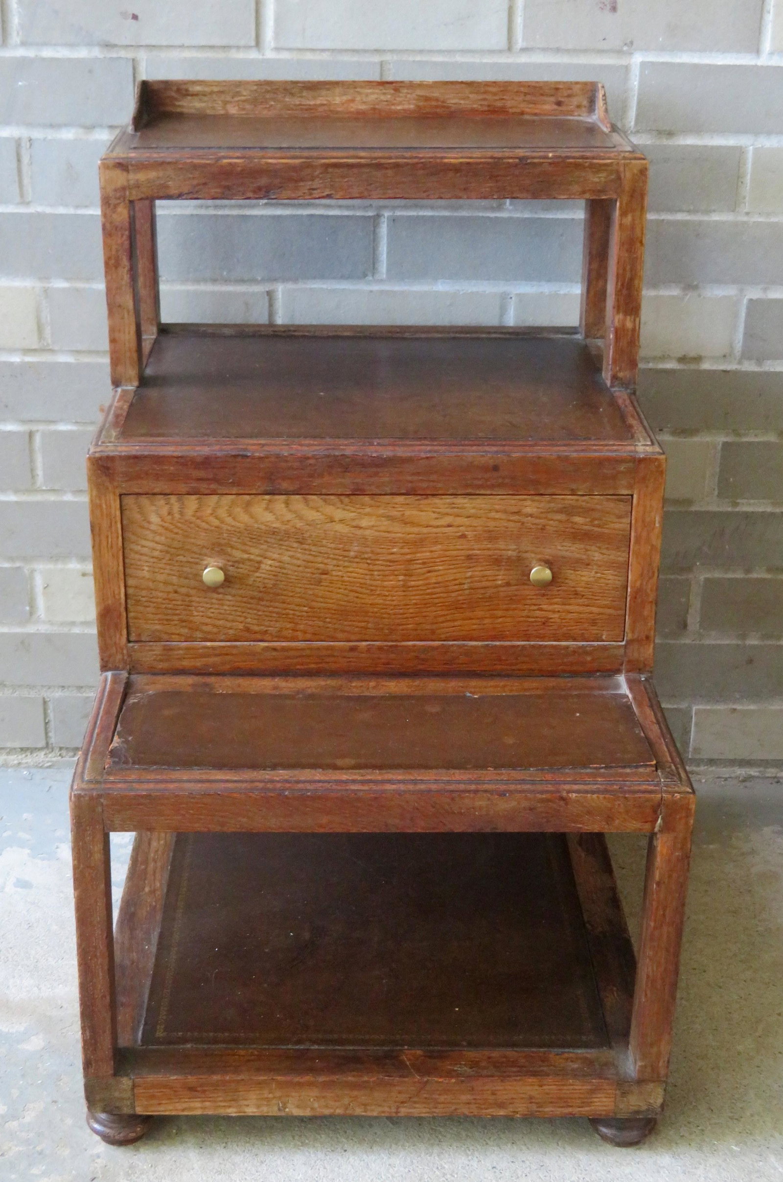 An oak bed step with tooled leather treads and single: An oak bed step with tooled leather treads and single central drawer, in the Federal style, early to mid 20th century. Very good condition. 16 1/4"W x 20 1/4"D x 27"H.