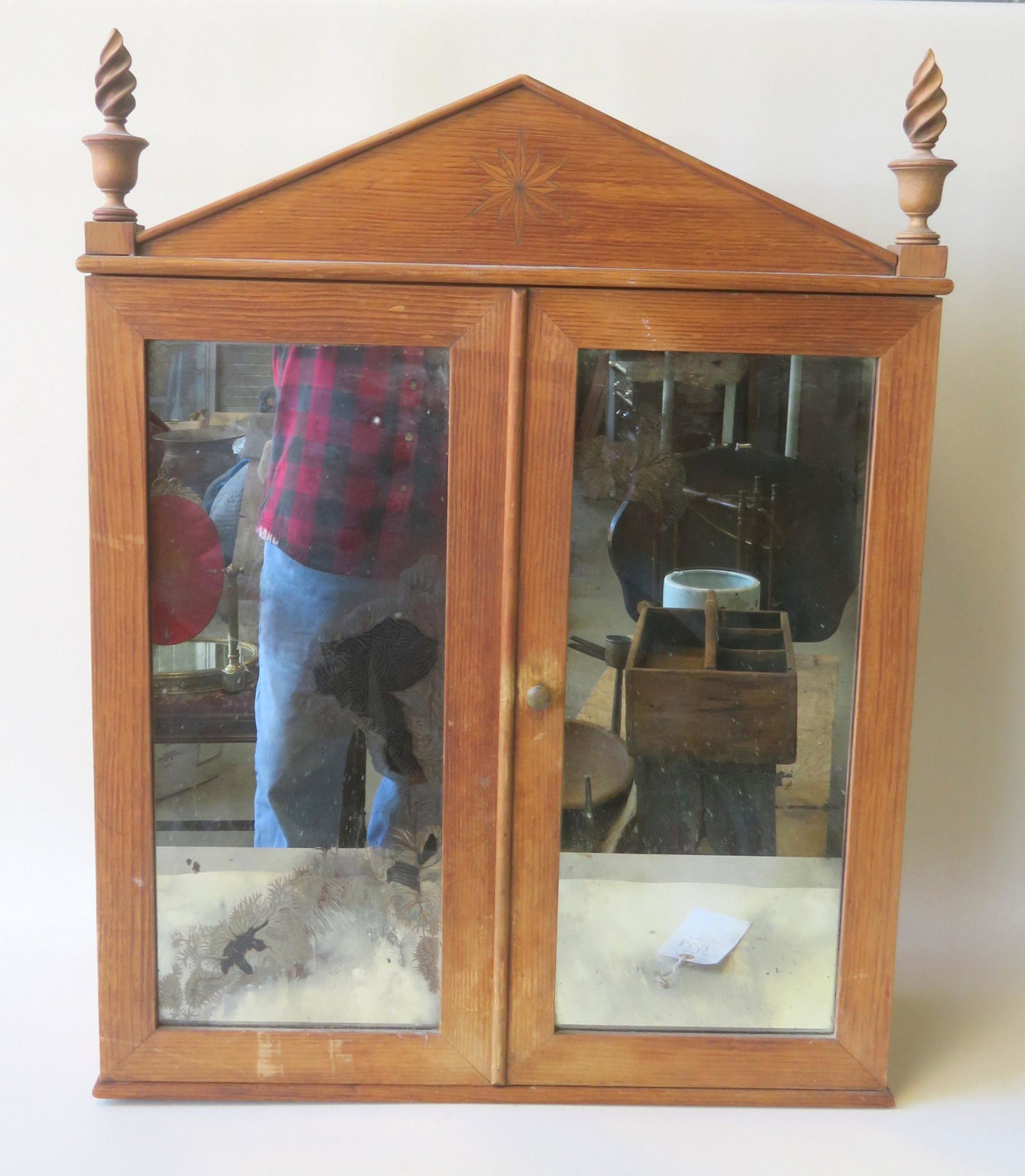 A 2 door wall cabinet with flame finials, early 20th: A 2 door wall cabinet with flame finials, early 20th century. Good condition. 24 1/2"W x 7 1/4"D x 32"H.