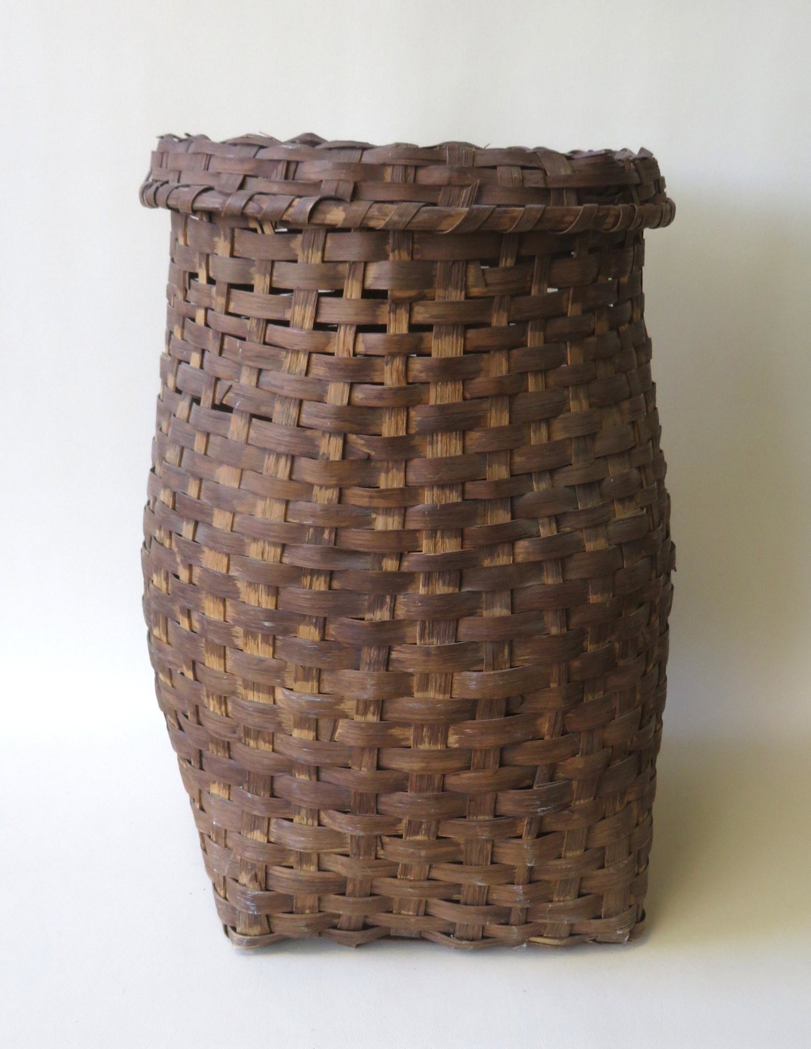Large covered feather basket in old brown stain - the: Large covered feather basket in old brown stain - the lid with a woven splint handle has several small breaks, but the basket in very good condition. 19th century. 22 1/4"H x 14 1/2"W.