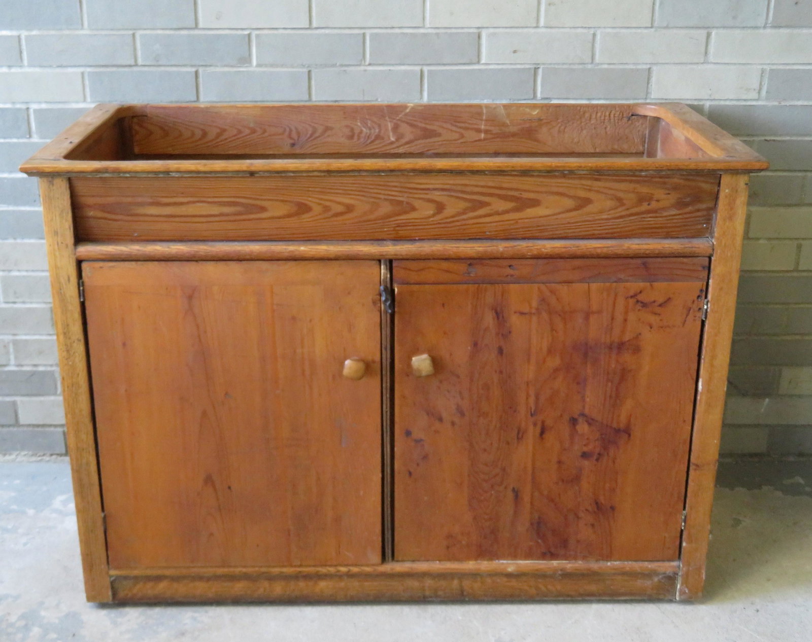 A make-do oak dry sink having a rectangular shaped well: A make-do oak dry sink having a rectangular shaped well over 2 doors, 43"W x 21"D x 30 1/2"H, missing interior shelf, otherwise good clean condition, probably made during the late 19th to early 20th c