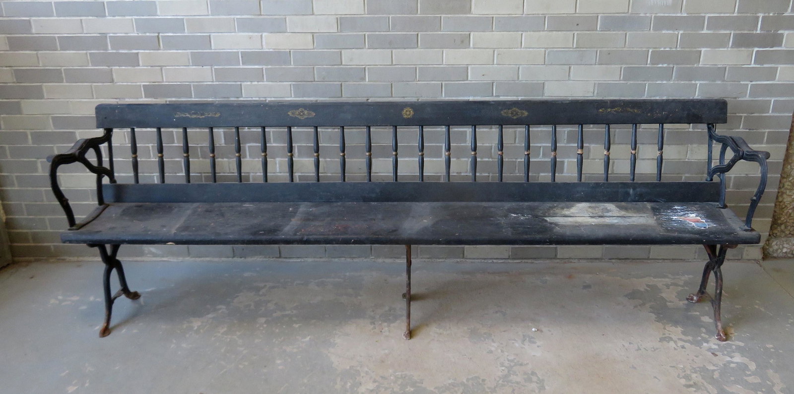 A spindle back railroad bench, in need of restoration,: A spindle back railroad bench, in need of restoration, 19th century - 96 1/2"W x 16"D x 32 1/2"H. Condition - losses to the cast iron support brackets that meet the top splat on the ends and have been