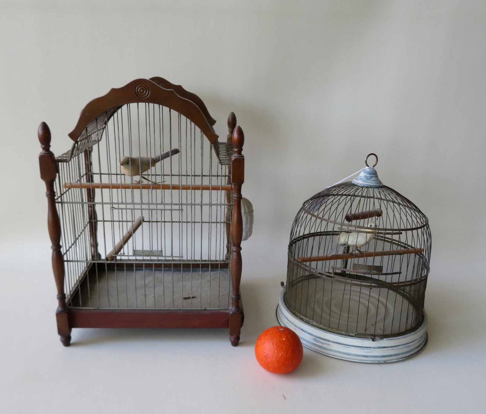 Two wire bird cages, the largest with wooden frame and: Two wire bird cages, the largest with wooden frame and signed Hendrix - 12"W x 10"D x 17 1/4"H. Both in good condition.