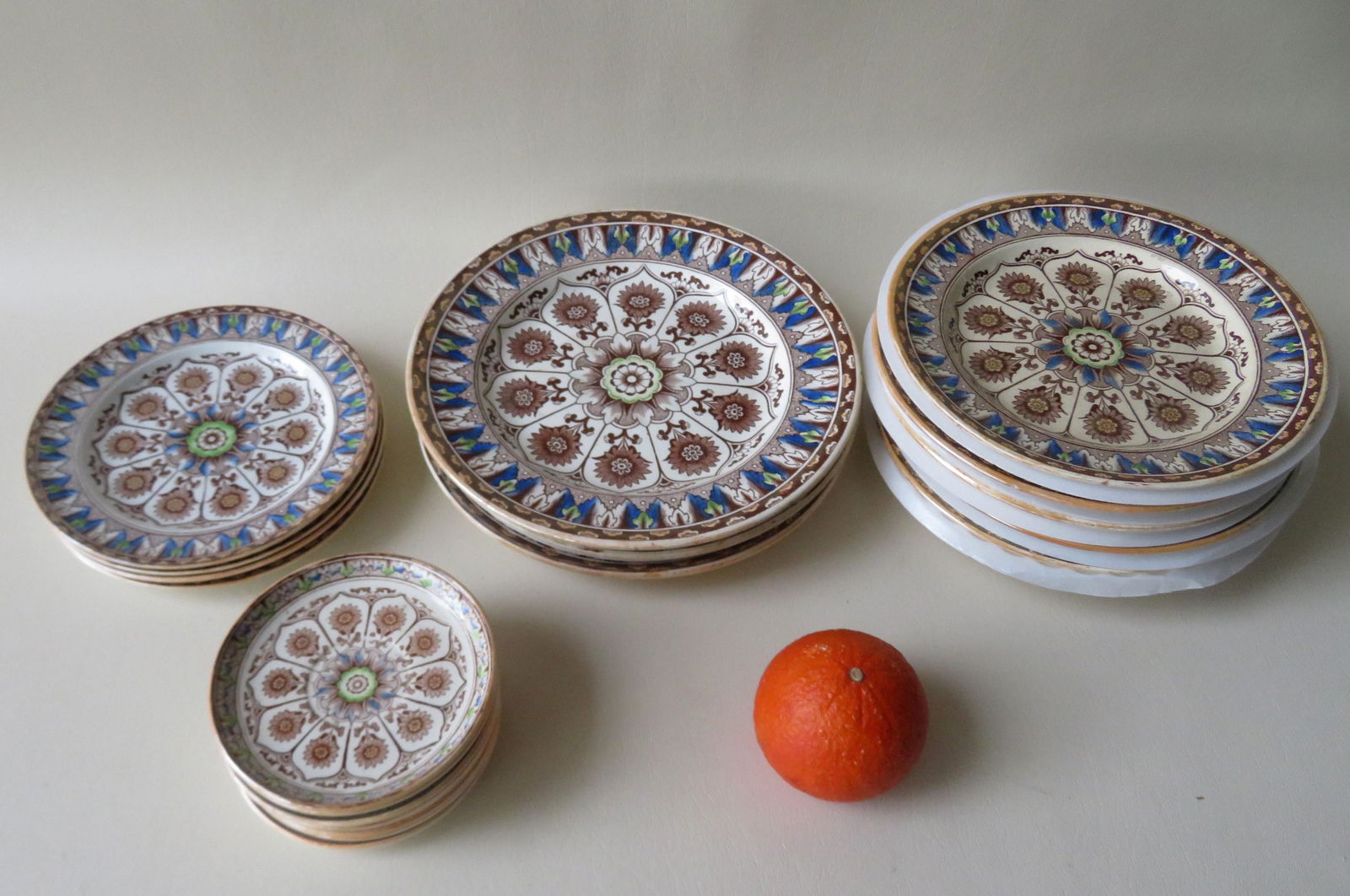 A grouping of English soft paste china by Brownfield &: A grouping of English soft paste china by Brownfield & Son, in the Cyprus pattern, circa 1871. Consists of three 9 1/2"D plates, six 8 3/8" D plates, four 7"D plates, and eight 4 3/4" coasters. All in