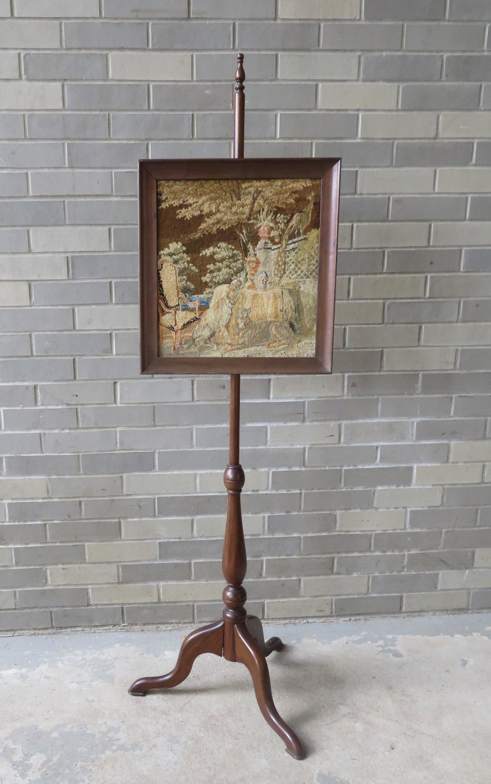 A federal style pole screen - the high quality: A federal style pole screen - the high quality needlepoint and pettipoint screen depicting a garden scene with a French style chair, 2 dogs and a peacock standing on architectural wall - minor blemish