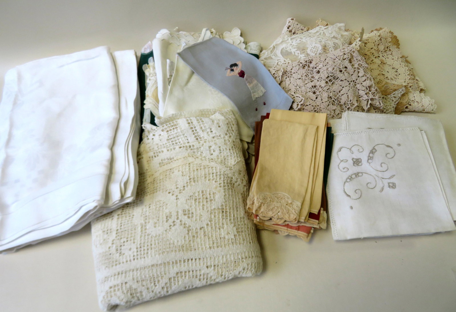 Grouping of various linens, most in very good: Grouping of various linens, most in very good condition. Includes 2 damask table cloths, 1 crochet table cloth, crochet and lace items. Combined with several silk scarves.