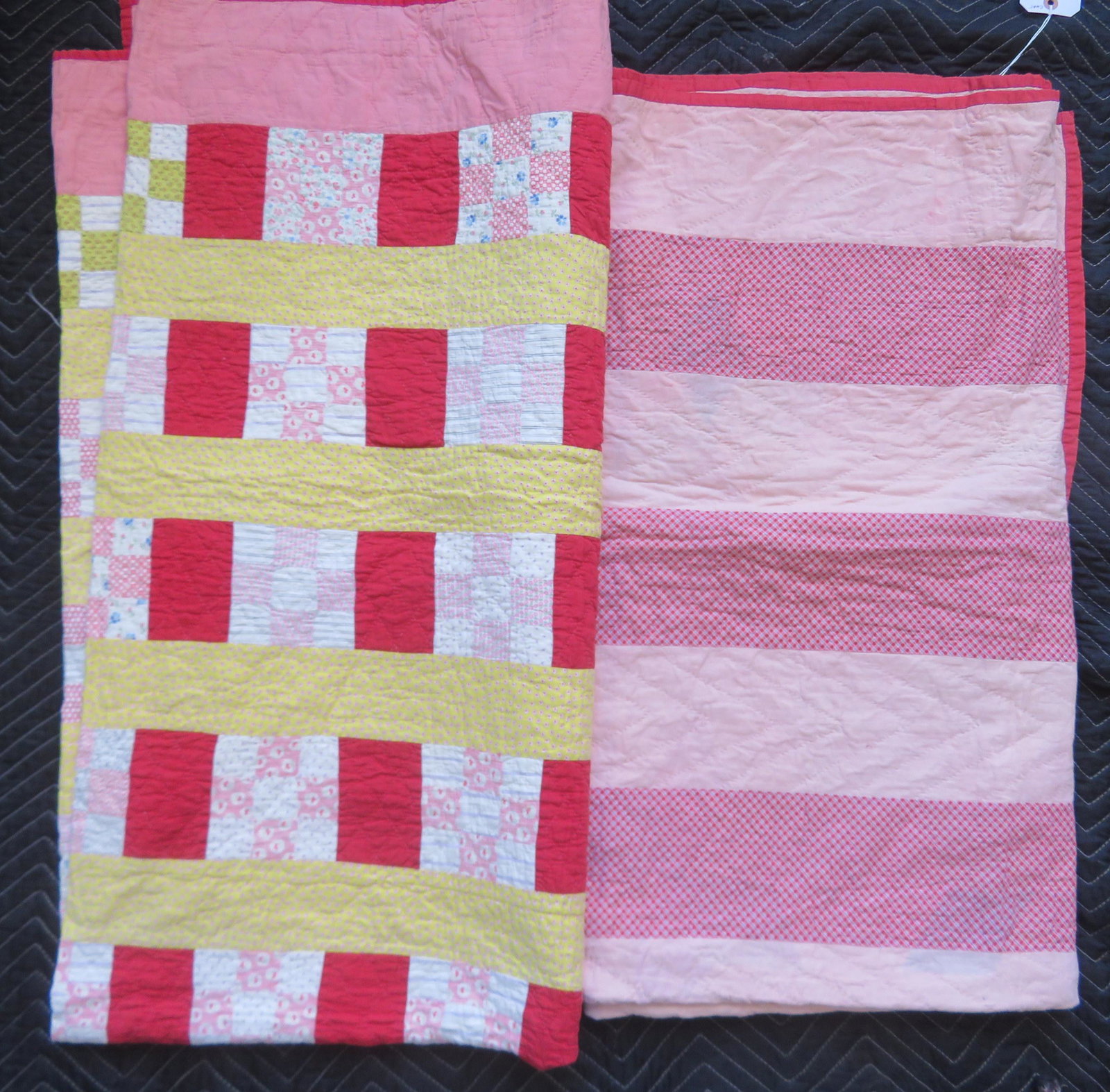 Two patchwork quilts, probably Pennsylvania in the: Two patchwork quilts, probably Pennsylvania in the Amish style. The first with pink stripes measures 67" x 75", and the second with yellow and red stripes with 9-patch variation measures 75" x 75". Bo