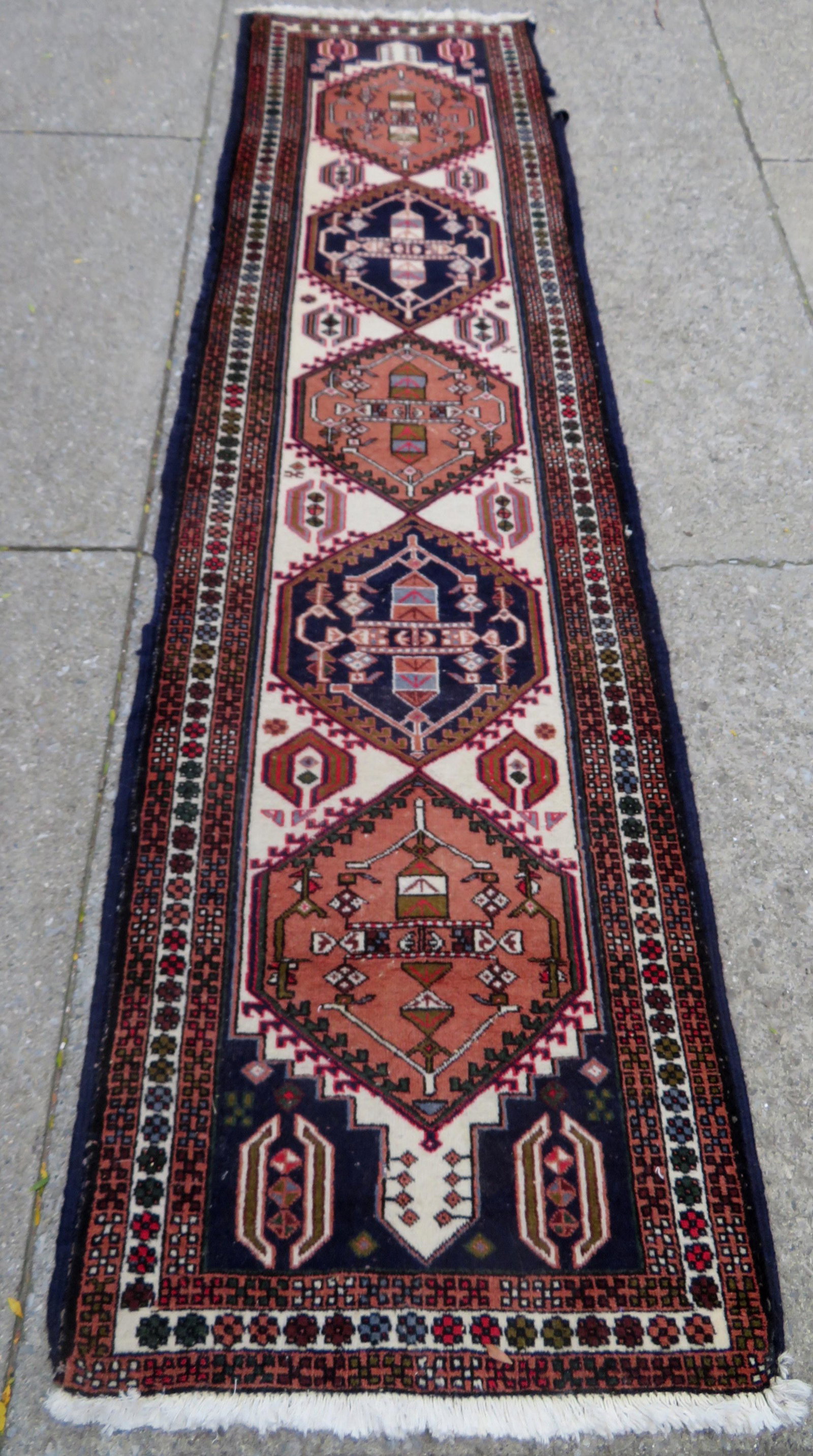 An oriental runner, mid to late 20th century, loose: An oriental runner, mid to late 20th century, loose threads on side of rug approximately 8"L, otherwise good condition - hand knotted - 2' 5 1/2" x 9' 8". Provenance: From the Stanley Blum estate, Rhi