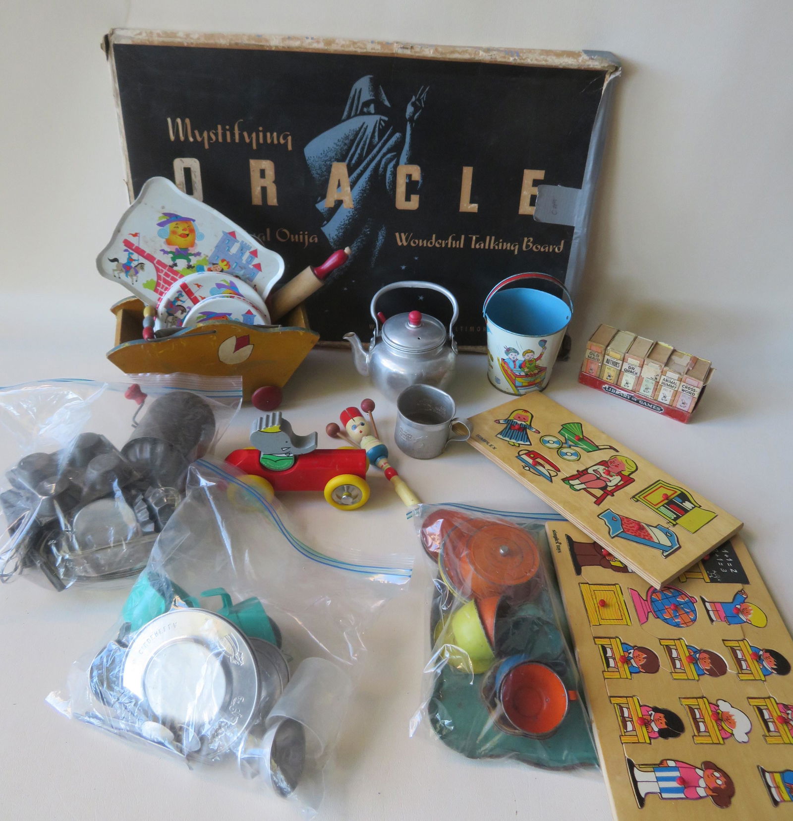 A grouping of miscellaneous vintage toys and kid: A grouping of miscellaneous vintage toys, most in good condition including tin kitchen sets circa 1950-60, a Barbar toy elephant driving car - Made in France - 1989 - very good condition, 2 Simplex pu