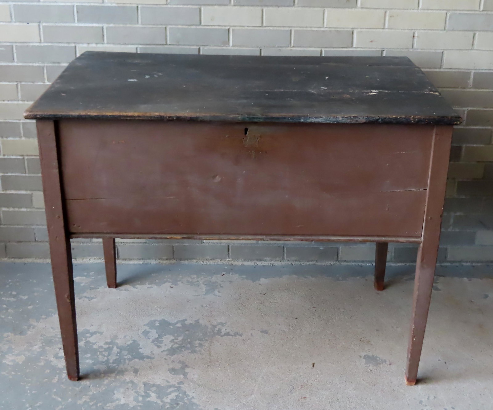 A primitive Hepplewhite country store lift-top desk: A primitive Hepplewhite country store lift-top desk with slanted top in original paint. The top in black and the frame in red. Condition: Replaced hinges, expansion crack in lid, lock and hasp removed
