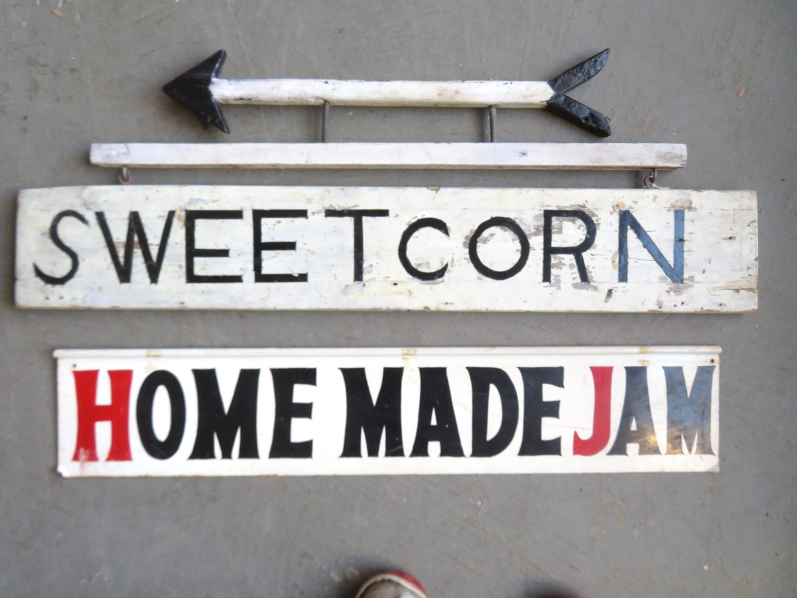 Two vintage farm double sided signs including: The: Two vintage farm double sided signs including: The first in wood, black lettering over white marked "SWEET CORN" - the sign hangs below a hand made wooden directional arrow - moderate use wear, but ov