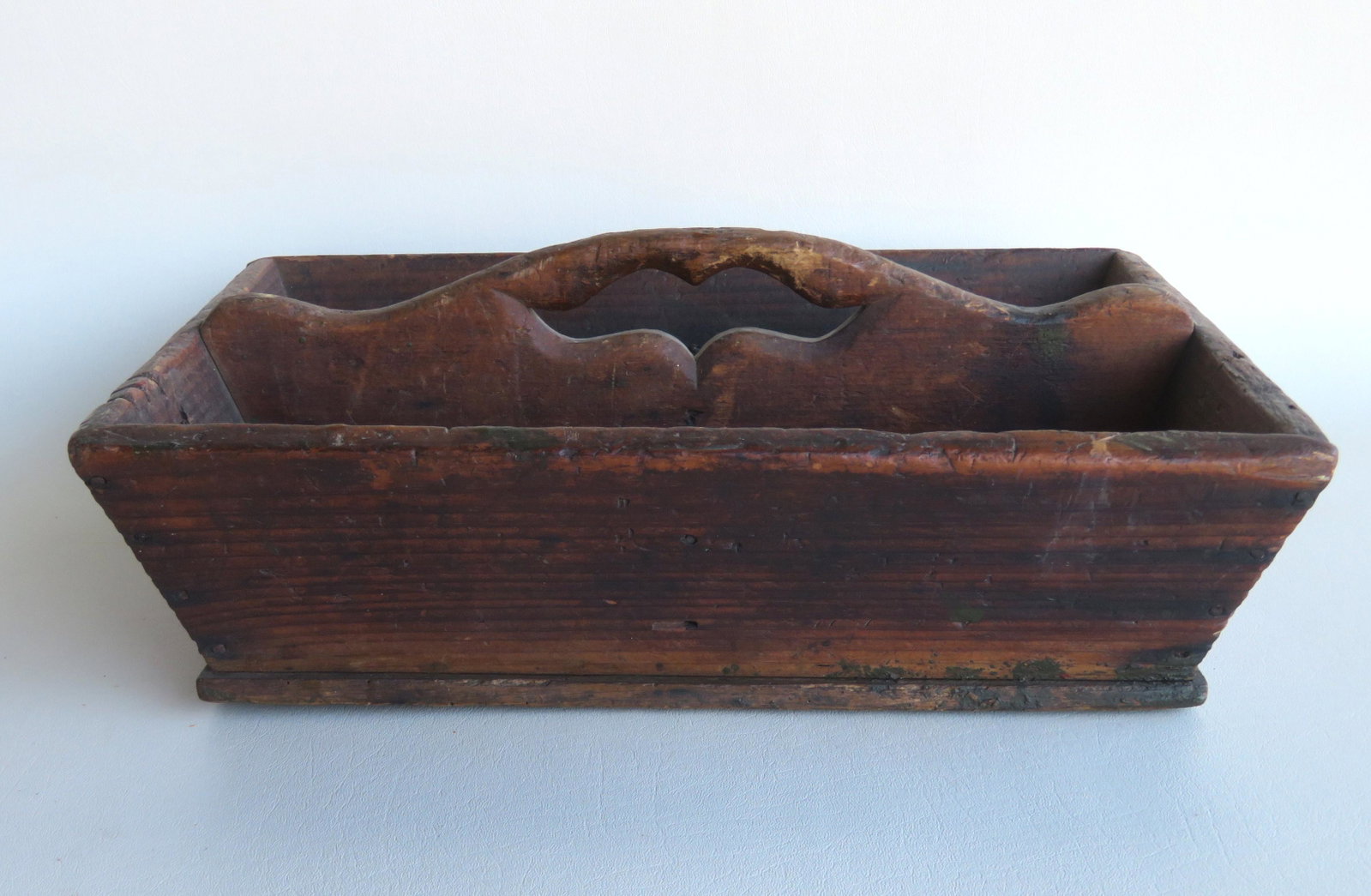 A primitive cutlery tray with mustache handle, square: A primitive cutlery tray with mustache handle, square nail construction in old original grungy finish, early 19th century. Measures 16 3/4"L x 12 1/2"W x 6"H. Use wear, but overall good condition. Pro