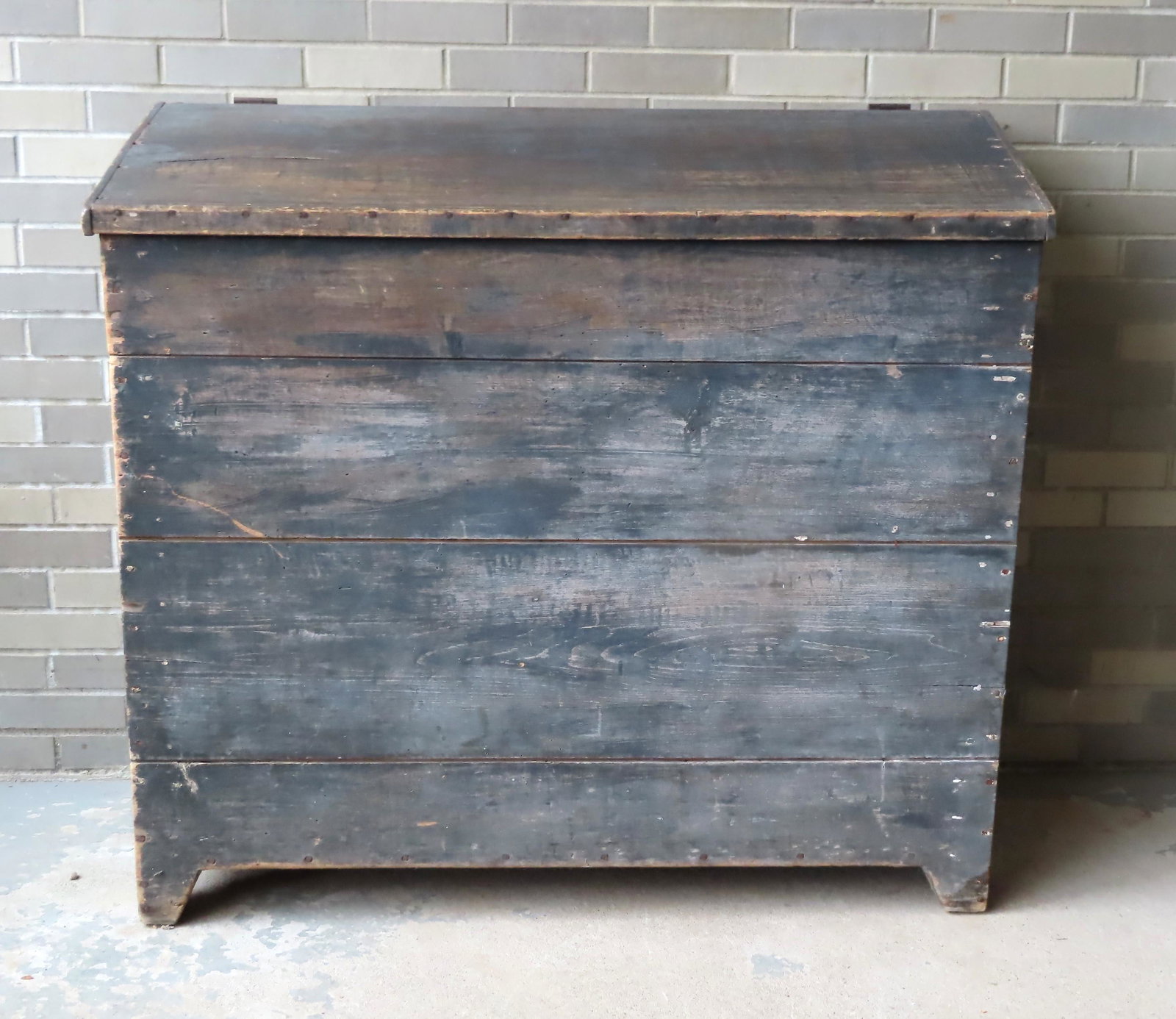 A large primitive grain box in original blue/green: A large primitive grain box in original blue/green paint with cutout sides, mid 19th century. Measures 47"W x 21 1/2"D x 42 1/2"H. Hairlines in lid, otherwise very good condition. Provenance: From a L