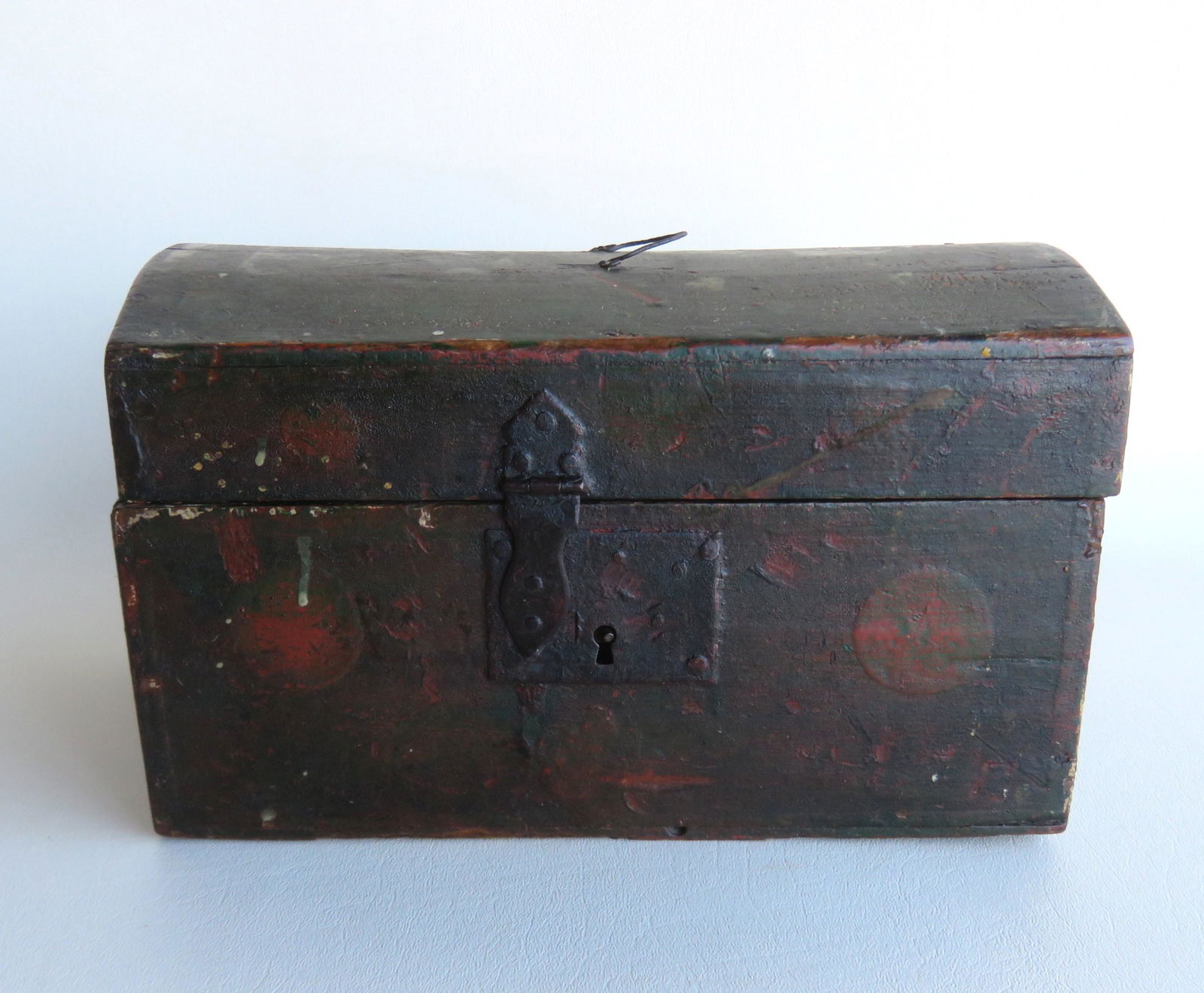 A small dome top document box with wire bail handle on: A small dome top document box with wire bail handle on lid and hand forged iron hasp & lock, in original green paint decorated with circles or fruit - the painted surface is very dirty and needs profe
