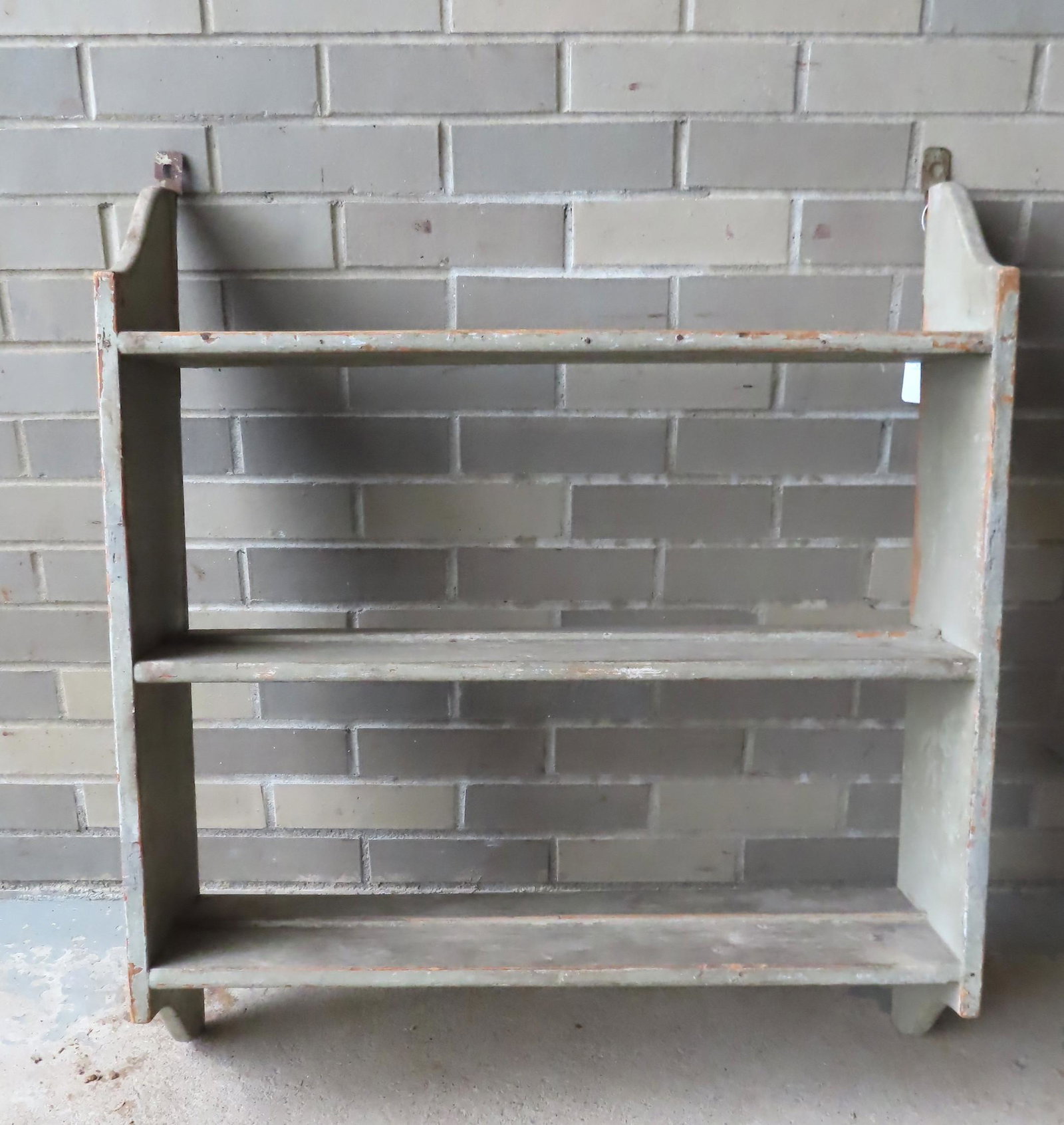 A good 3 tier wall shelf with cutout sides, in old: A good 3 tier wall shelf with cutout sides, in old paint, 19th century. 28 1/2"W x 8"D x 33"H. Very good condition.