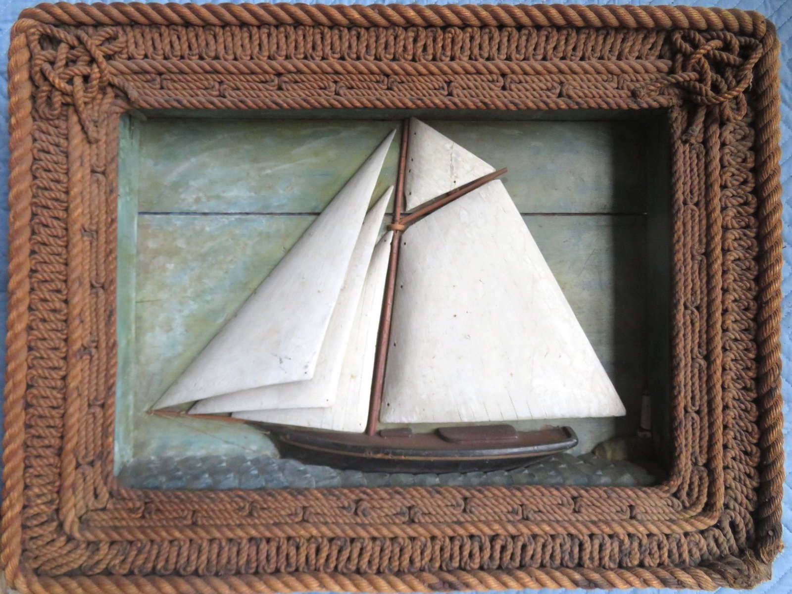 A hand made sailing ship diorama, hand painted single: A hand made sailing ship diorama, hand painted single mast ship with wooden sails, and wooden waves - wooden light house distant. Very good condition. 28 1/4"W x 5"D x 22 1/4"H. The frame decorated wi