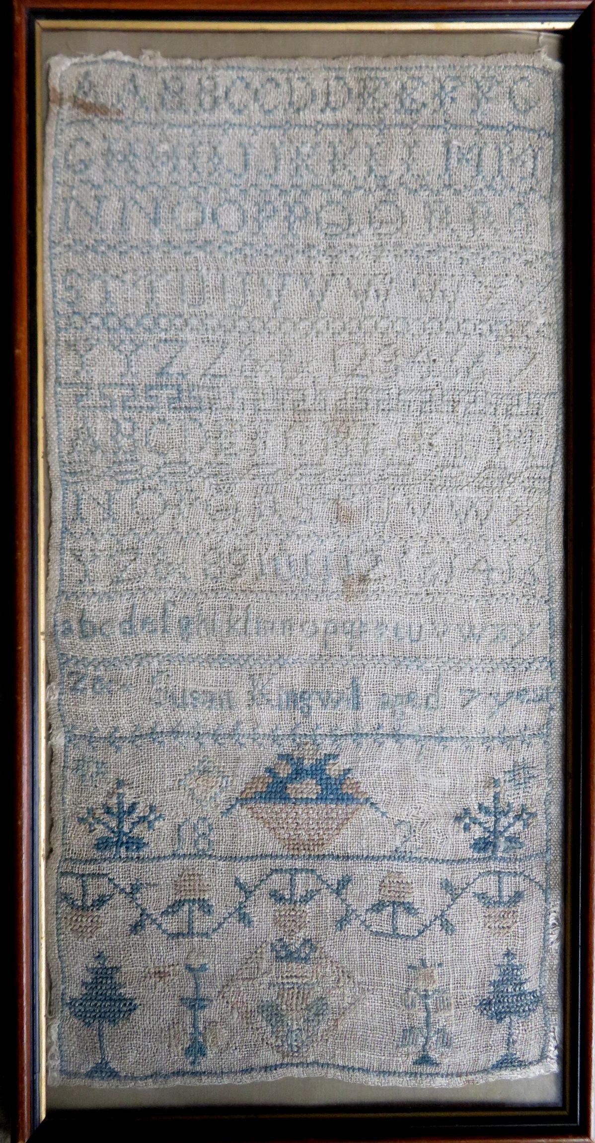 An alphabet and pictorial sampler, signed "Susan: An alphabet and pictorial sampler, signed "Susan Kingwell / Aged 7 Years" and dated 1824. Good condition. Sampler size 7 1/2" x 16" - total frame size 8 1/2" x 16 3/4". There is an old paper label att