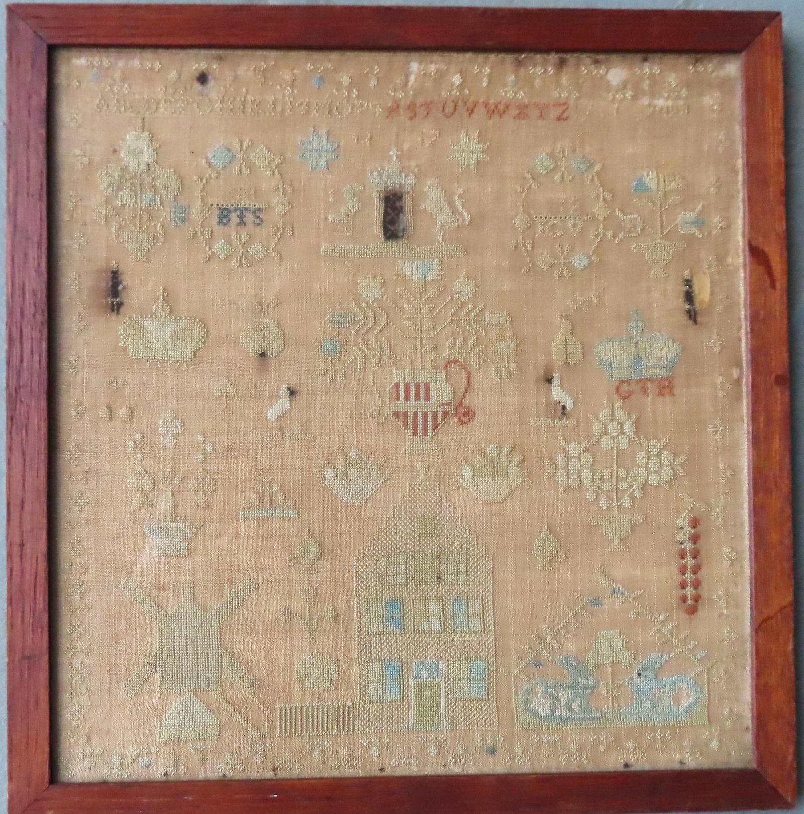 A European pictorial sampler with alphabet, early 19th: A European pictorial sampler with alphabet, early 19th century. Decorated with an urn with flowers over a farmhouse with picket fence, flanked by a windmill to the left and 2 resting rabbits to the ri