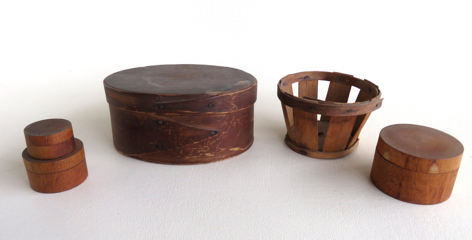 Two small country items including an oval box with: Two small country items including an oval box with lapped finger in darkened stain, circa 1850 - 5 7/8" x 4 1/2" (top) x 2 5/8"H - good condition; 3 circular pill boxes in graduated size - the largest