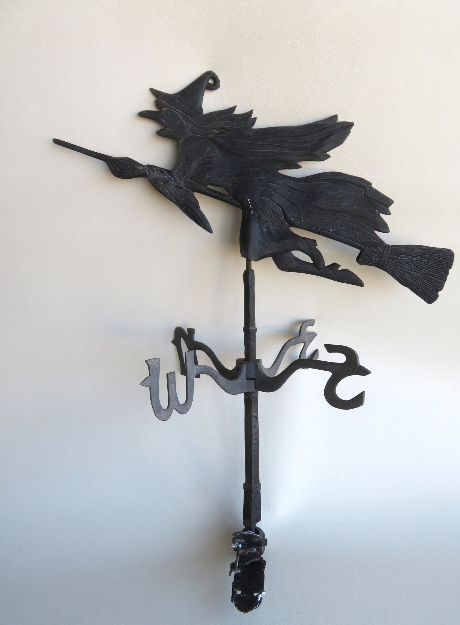 A silhouette aluminum molded Witch on Broom weathervane: A silhouette aluminum molded Witch on Broom weathervane on arrow with directionals, copyright "1988 WS". Very good condition in old black paint. Measures 21"L x 14"H. Directionals - 15"W and total hei