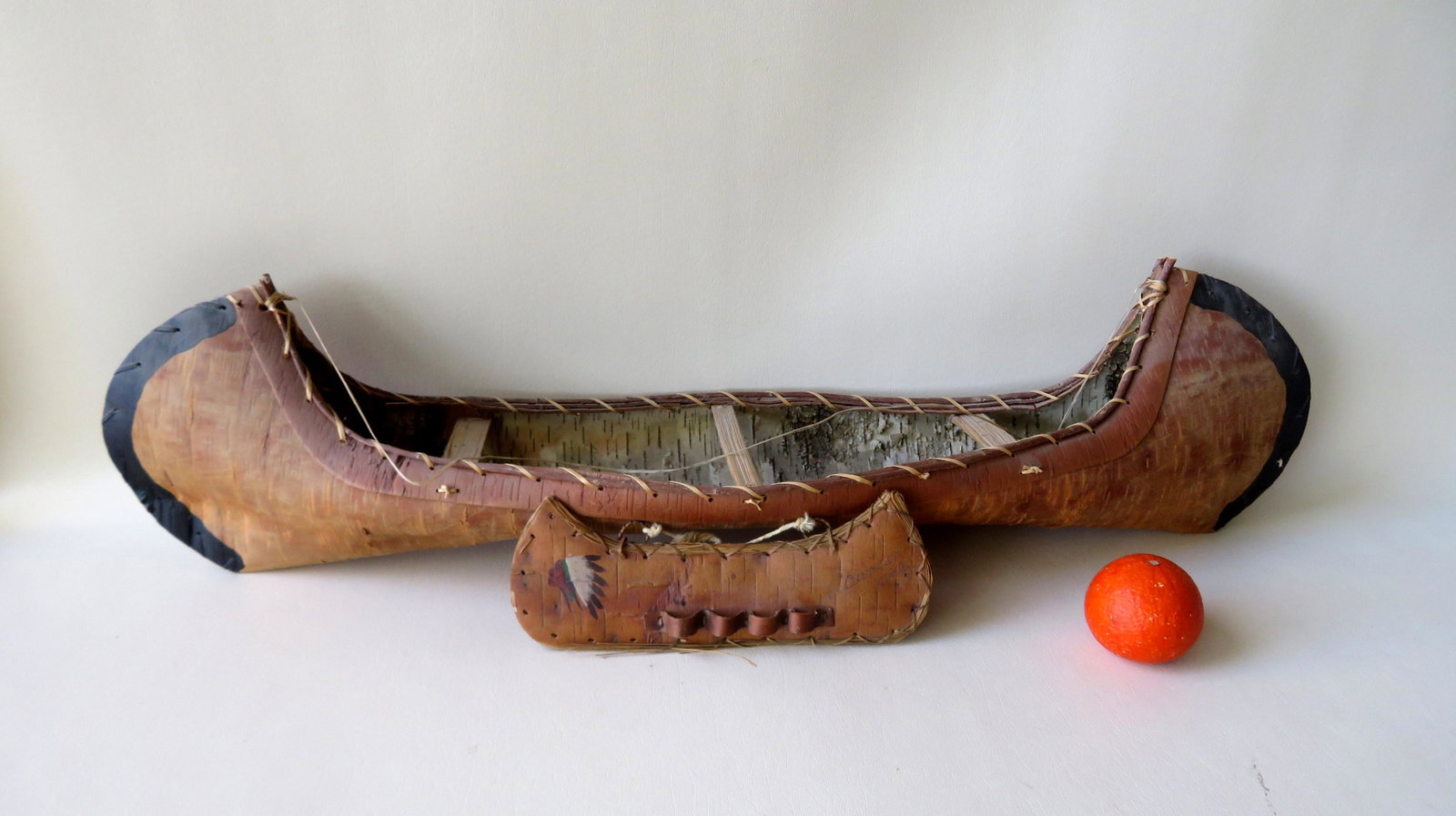 Two birch bark souvenir canoe models. The first a large: Two birch bark souvenir canoe models. The first a large model with black painted highlights - 36"L x 8 1/2"W x 9"H - very good condition - mid to late 20th century; and an older and small canoe in the