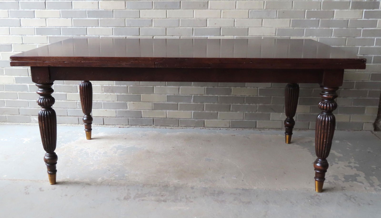 Contemporary refractory table on turned legs: Guido Zichele designed refractory table in maple with walnut inlays and distressed finish to top, mounted on turned legs terminating in brass clad feet, late 20th century, branded "Made in Italy" and