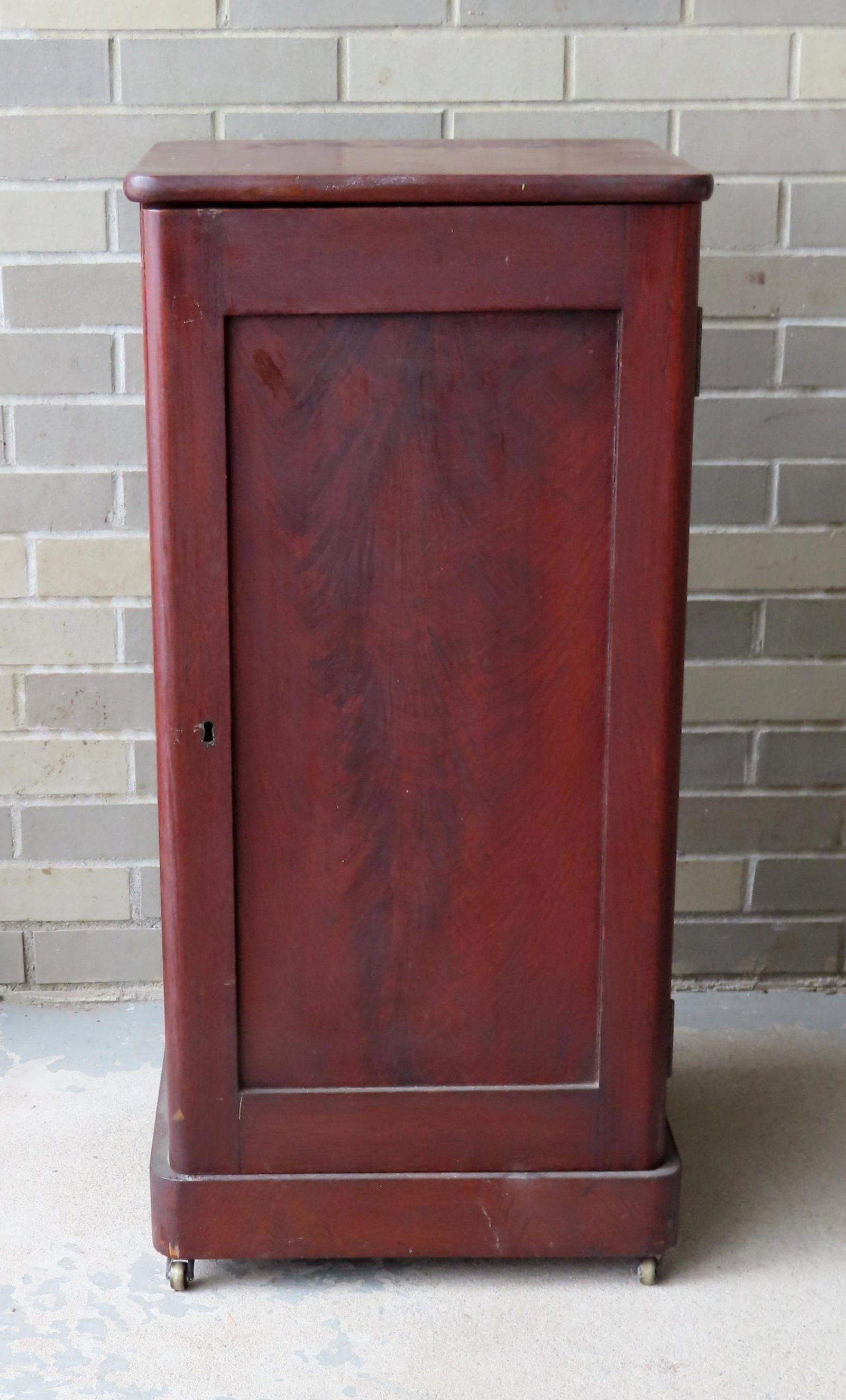 A small Empire mahogany single door storage cabinet -: A small Empire mahogany single door storage cabinet - the top with an expansion crack, otherwise good condition. Circa 1850. Measures 17"W x 17 1/2"D x 35 1/4"H. Provenance: From the estate of Zane Z.