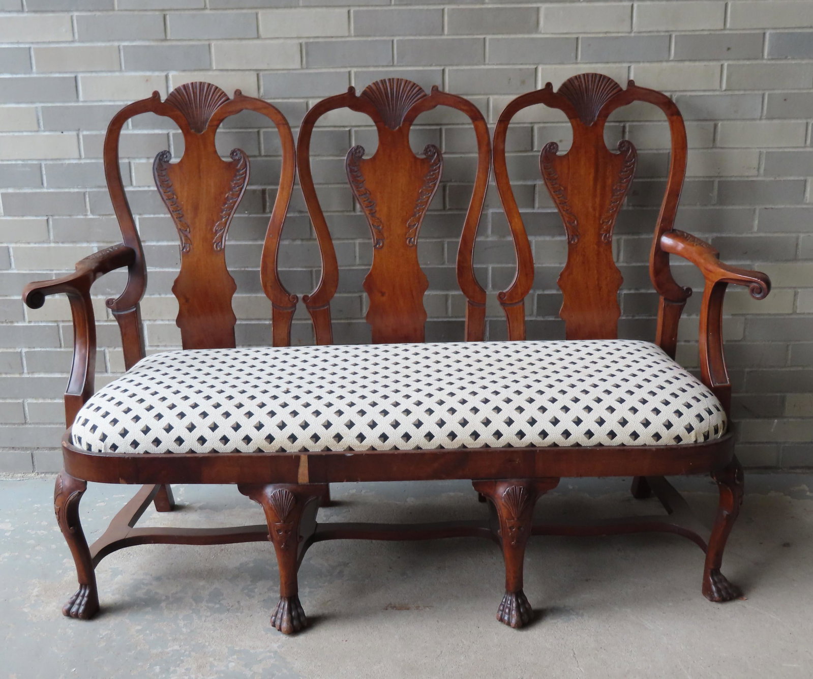 A wonderful Chippendale style mahogany triple bench: A wonderful Chippendale style mahogany triple bench with scrolled arms, serpentine shaped cross stretchers, shell carved crest, acanthus carvings on back splat and arm terminals, and shell carvings on