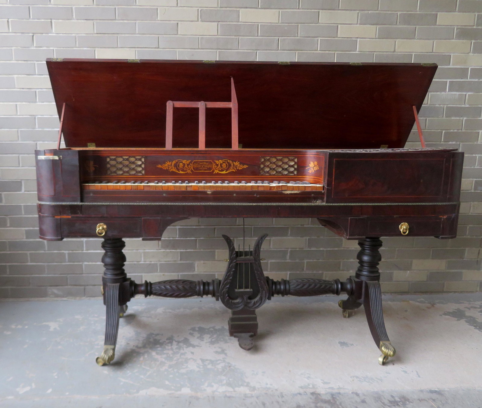 A Federal mahogany "square piano" signed in gilt on the: A Federal mahogany "square piano" signed in gilt on the front board "New Patent / Ryder & Thomas / New York". The keyboard is flanked by 2 lower drawers and the base with a lyre ornament above foot pe