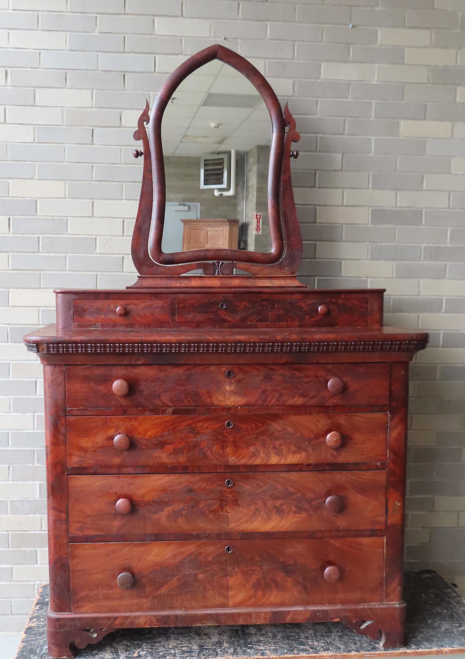 Mahogany Empire gothic dresser having original mirror: Mahogany Empire gothic dresser having original mirror with 3 small drawers over 4 graduated drawers on bracket base, circa 1850. Missing piece of molding on right side, otherwise good condition. Measu