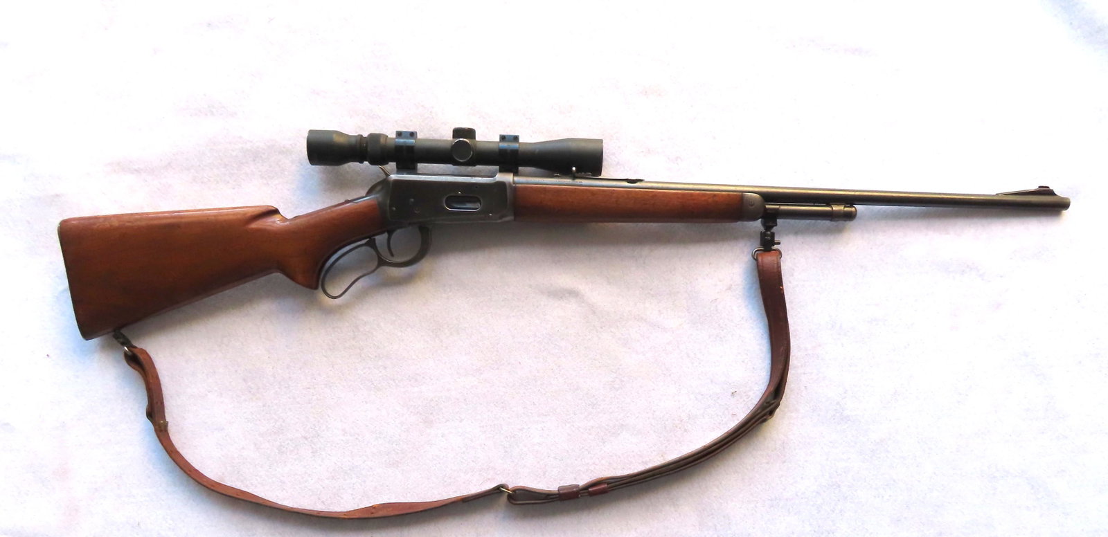 Winchester Model 64, 32 caliber (Winchester Special),: Winchester Model 64, 32 caliber (Winchester Special), lever action, with shoulder strap. A Tasco scope has been added and mounted to left side of receiver. Small area of pitting on receiver, and recei
