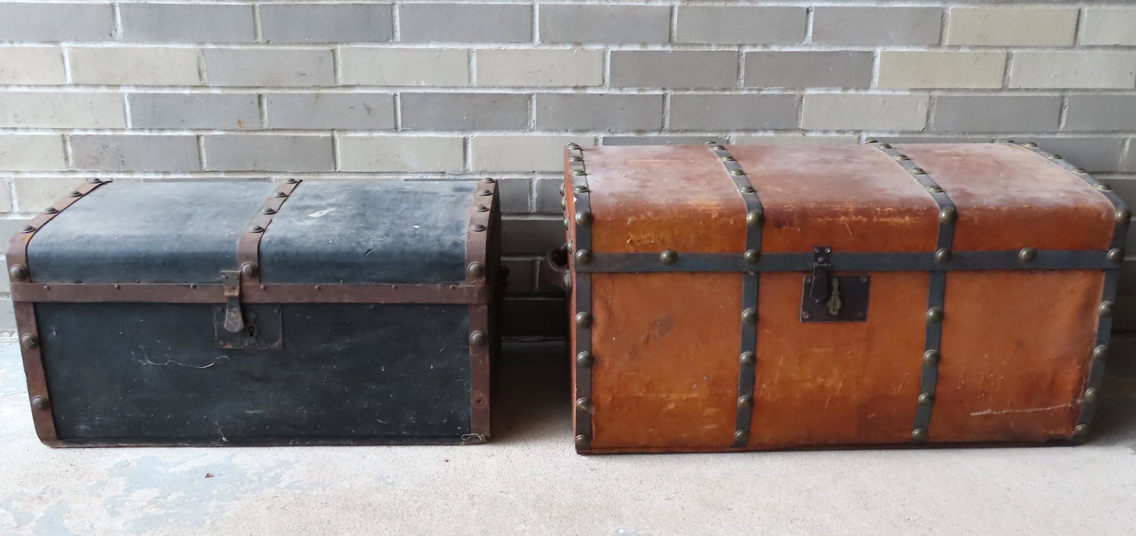 Two leather stagecoach trunks with brass studs and: Two leather stagecoach trunks with brass studs and wallpapered interiors. The size of the largest 28"W x 16"D x 14"H. Provenance: From the estate of Zane Z. Studenroth Jr., Hudson NY.