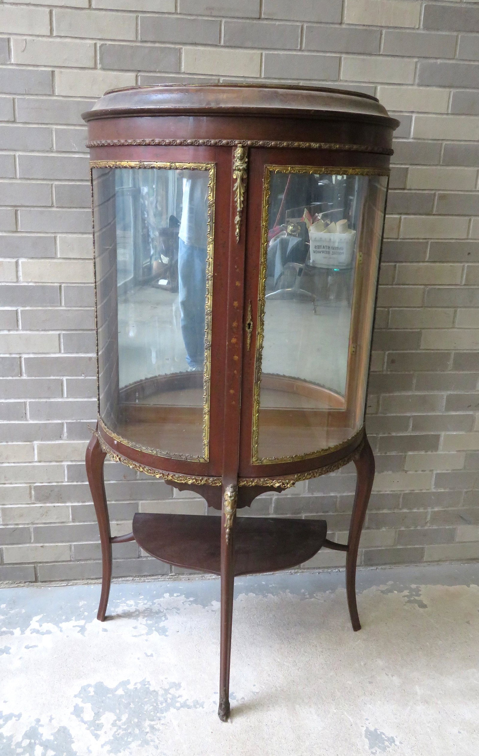 French style vitrine with curved glass sides and front: French style vitrine with curved glass sides and front with single door, applied ormolu, decorated with hand painted miniature flowers, 2 glass shelves (one with chip in corner). Good condition, late 