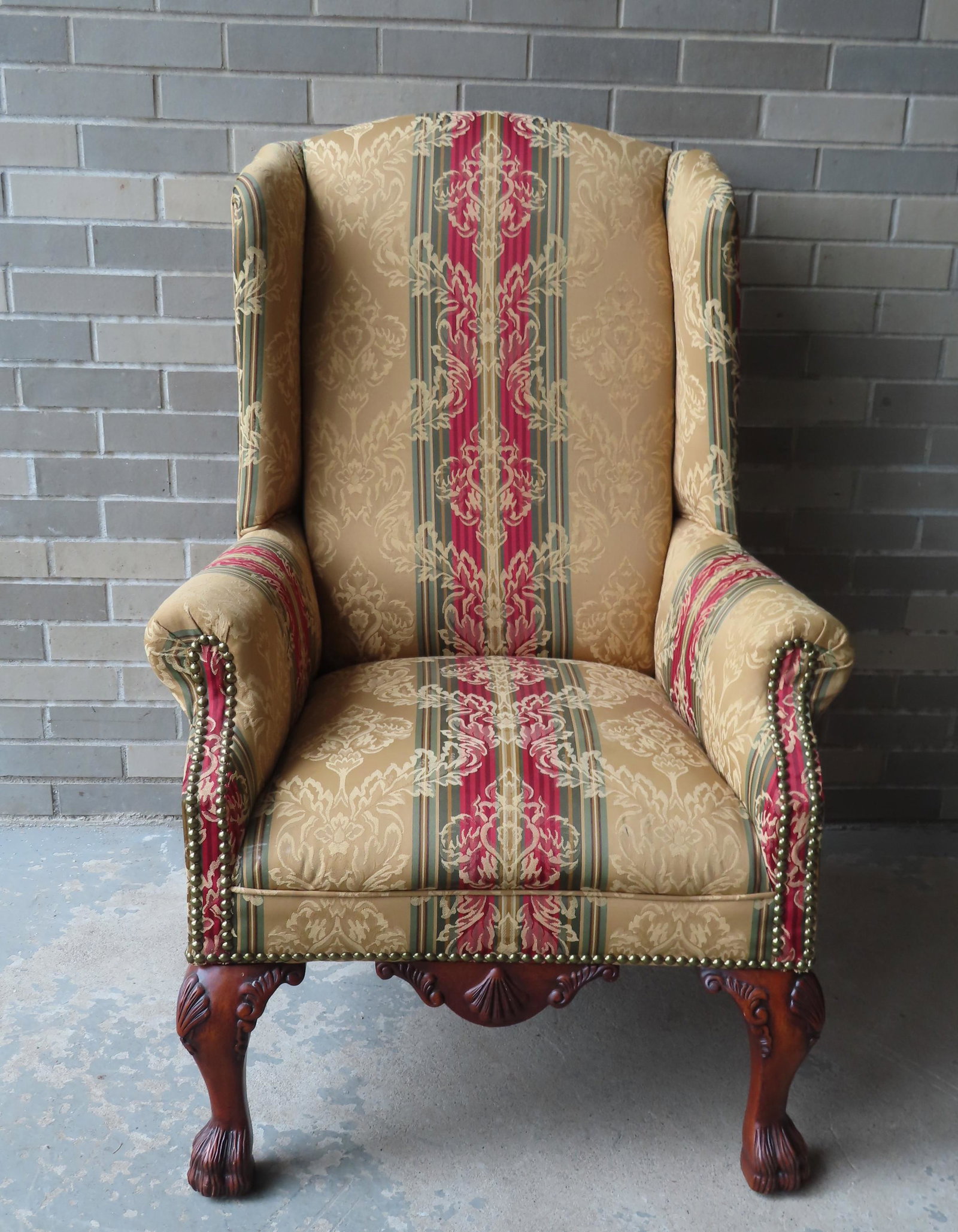 A Chippendale style wing chair, with newer classical: A Chippendale style wing chair, with newer classical upholstering with brass tacks. The claw feet with some surface scratches, one back leg with small chip, the upholstery in very good condition. 44"H