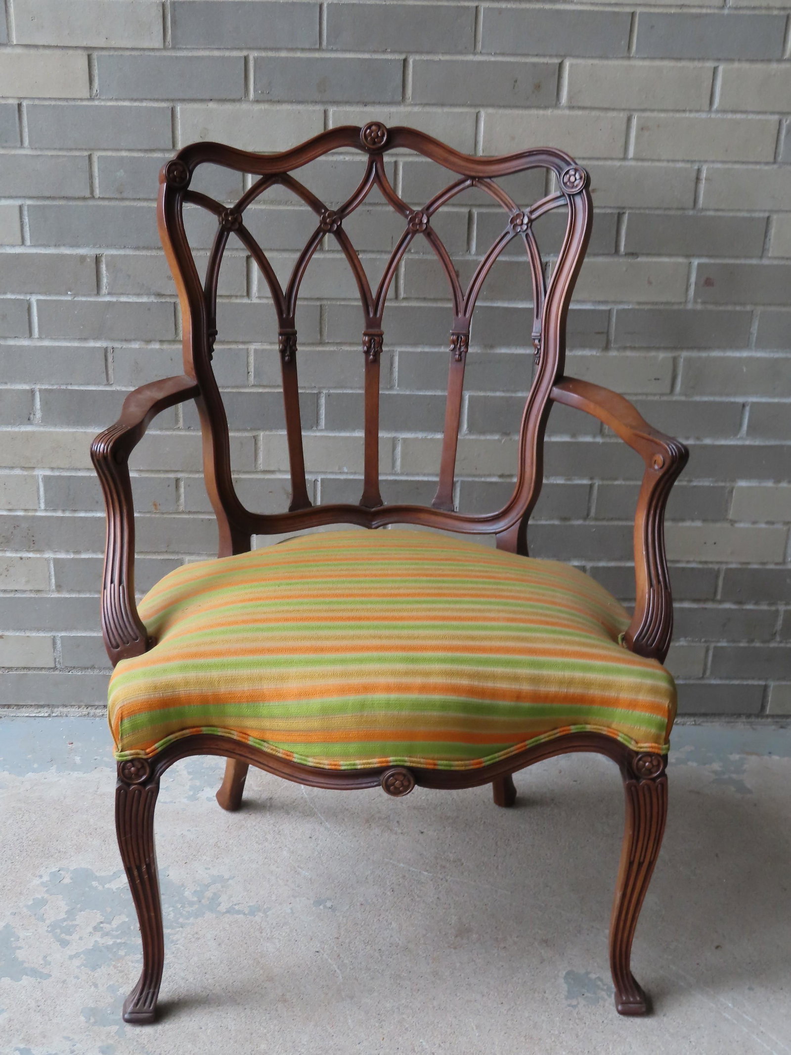 An Italianate Chippendale style arm chair with curved: An Italianate Chippendale style arm chair with curved and fluted legs and arms, and newer upholstered seat, probably late 19th century (possibly earlier). Very good condition. 26 1/2"W x 20"D x 19"H (