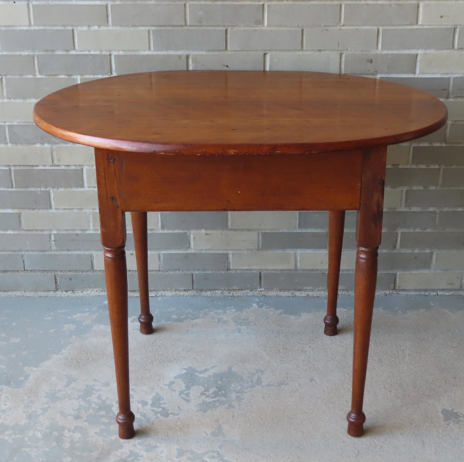 A country cherry tap table with turned legs, with: A country cherry tap table with turned legs, with restoration. The top a replacement constructed of old drop leaves, and 2 of the feet have been broken off and reattached - see the similar wear on all