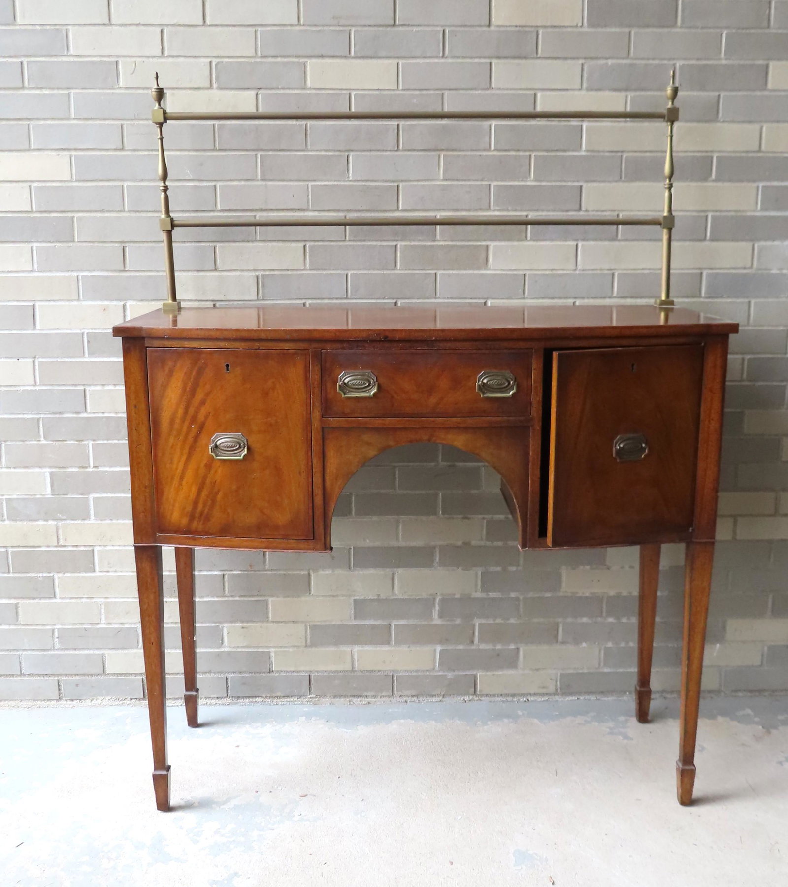 A good Hepplewhite style mahogany server with brass: A good Hepplewhite style mahogany server with brass railings and having a central segmented drawer flanked by a deep drawer on the left and a storage unit with hinged door on the right. The tapered le