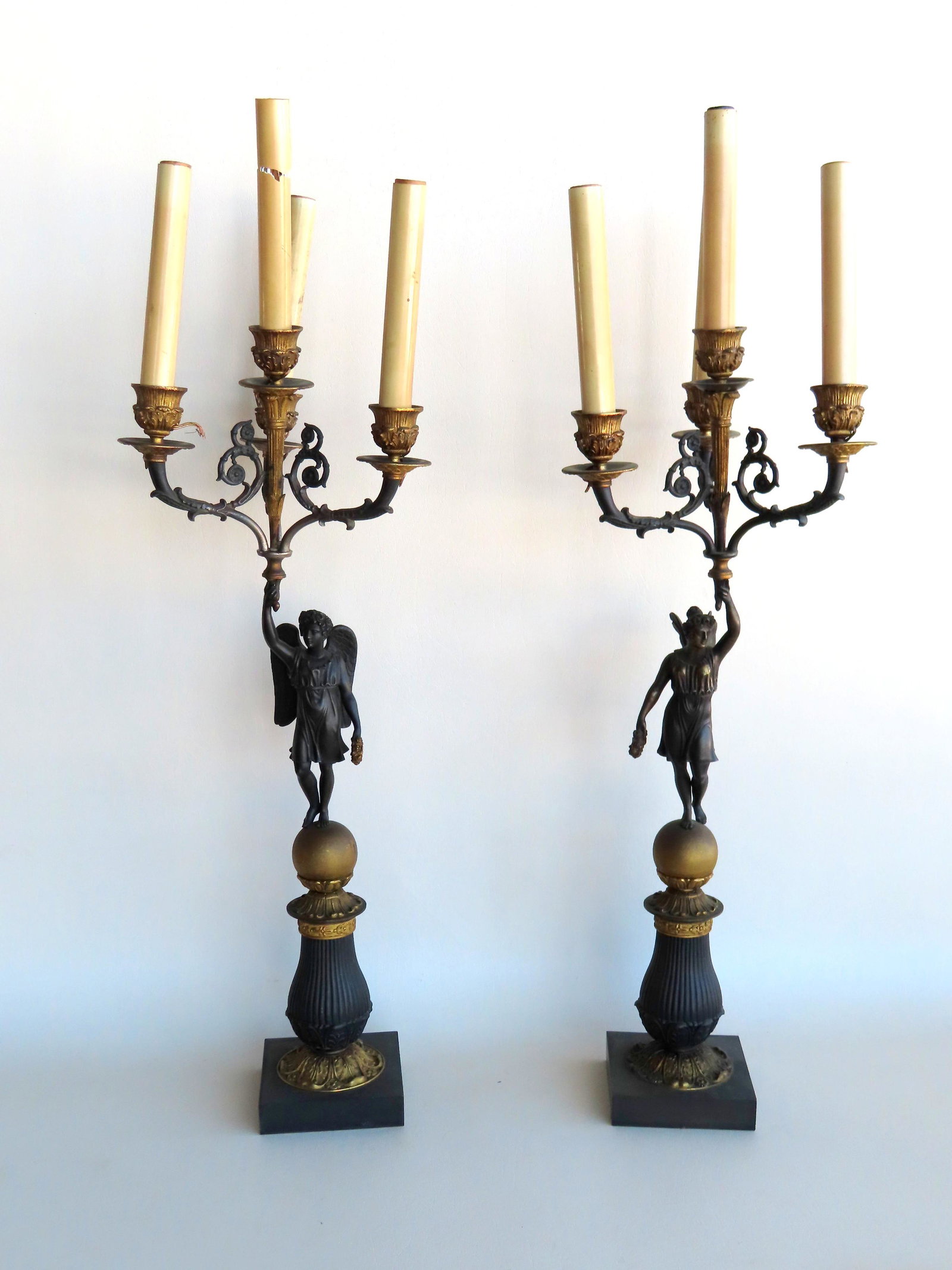 Two classical matching torchiere candelabras, probably: Two classical matching torchiere candelabras, probably zinc including sculptures of an angel and goddess, each holding a 4 light torchiere, gilded and bronze finishes. The female with butterfly wings,