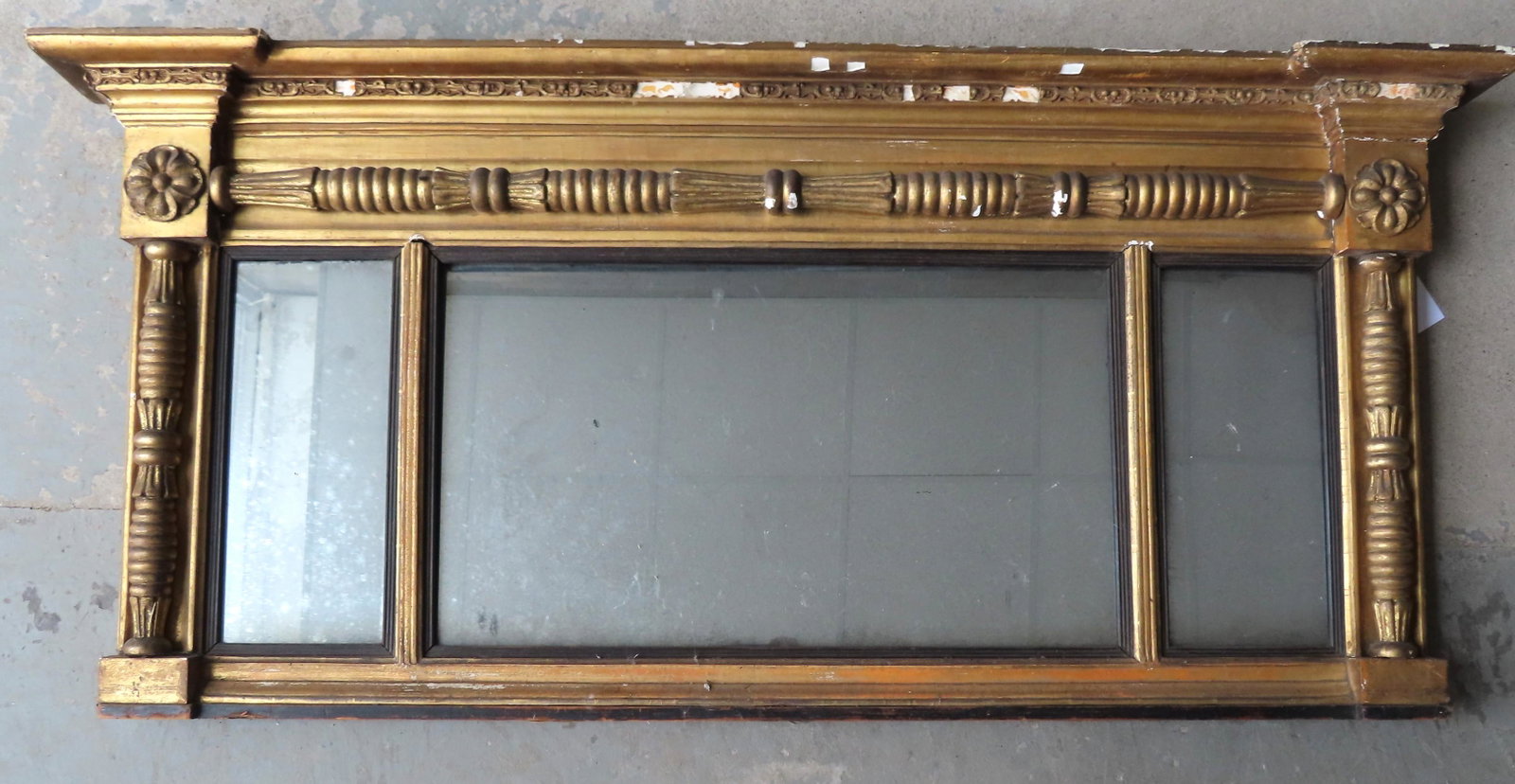 A Federal over mantle mirror in gilt gesso, having a: A Federal over mantle mirror in gilt gesso, having a stepped cornice with applied decorative gesso (gesso with losses), over a fancy turned gilded gesso horizontal column flanked by rosettes in corner