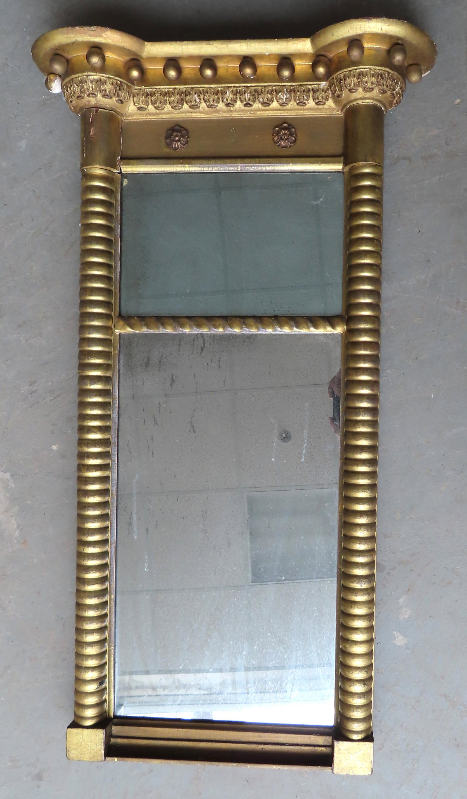 A beautiful Sheraton double panel wall mirror having a: A beautiful Sheraton double panel wall mirror having a shaped top with hanging orbs below over a central panel with 2 applied gesso rosettes flanked by spool turned 1/2 columns leading to square base.