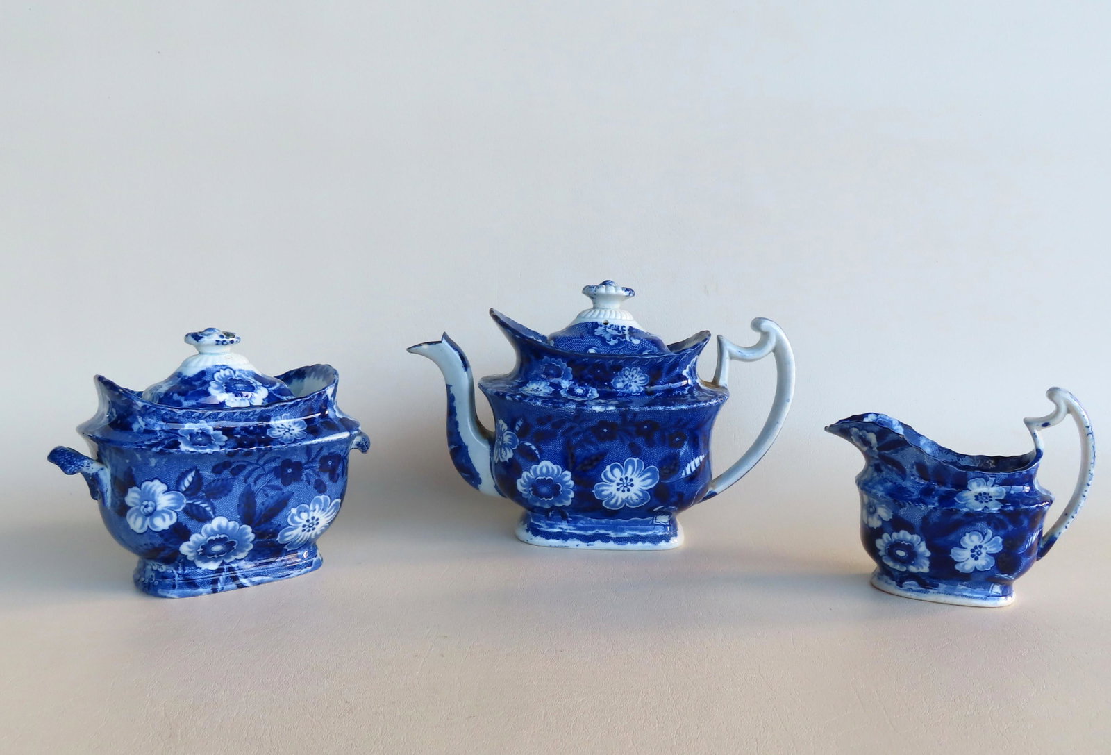 A Staffordshire porcelain blue and white tea service: A Staffordshire porcelain blue and white tea service including teapot, sugar and creamer, mid 19th century. The teapot measures 10 1/2"L x 5"W x 7"H. Condition: Creamer - no damage; sugar bowl with sm