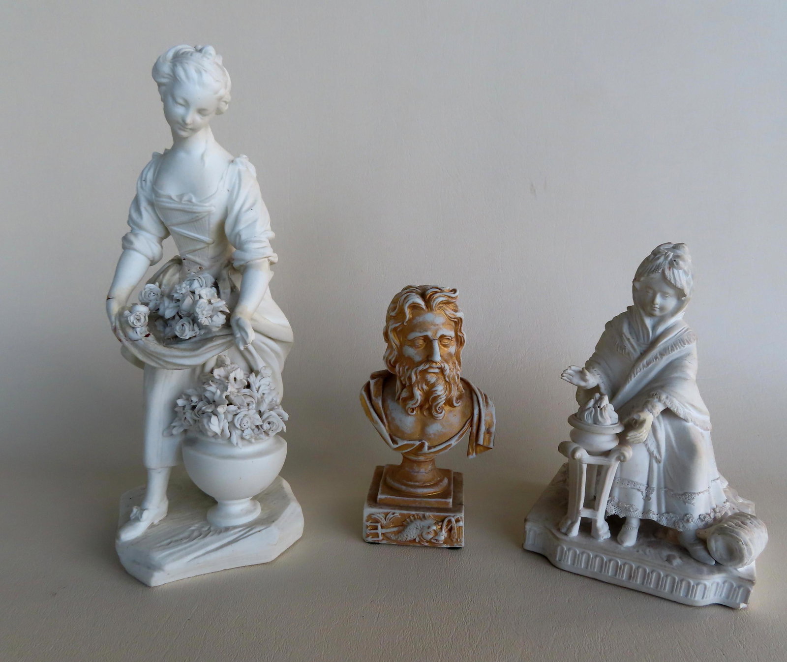 Three parian ware sculptures, 19th century. The first: Three parian ware sculptures, 19th century. The first of a lady with flowers - xx"H, repair to hand, otherwise good condition; the second of a lady with a bowl of fruit - losses to tips of fingers; an