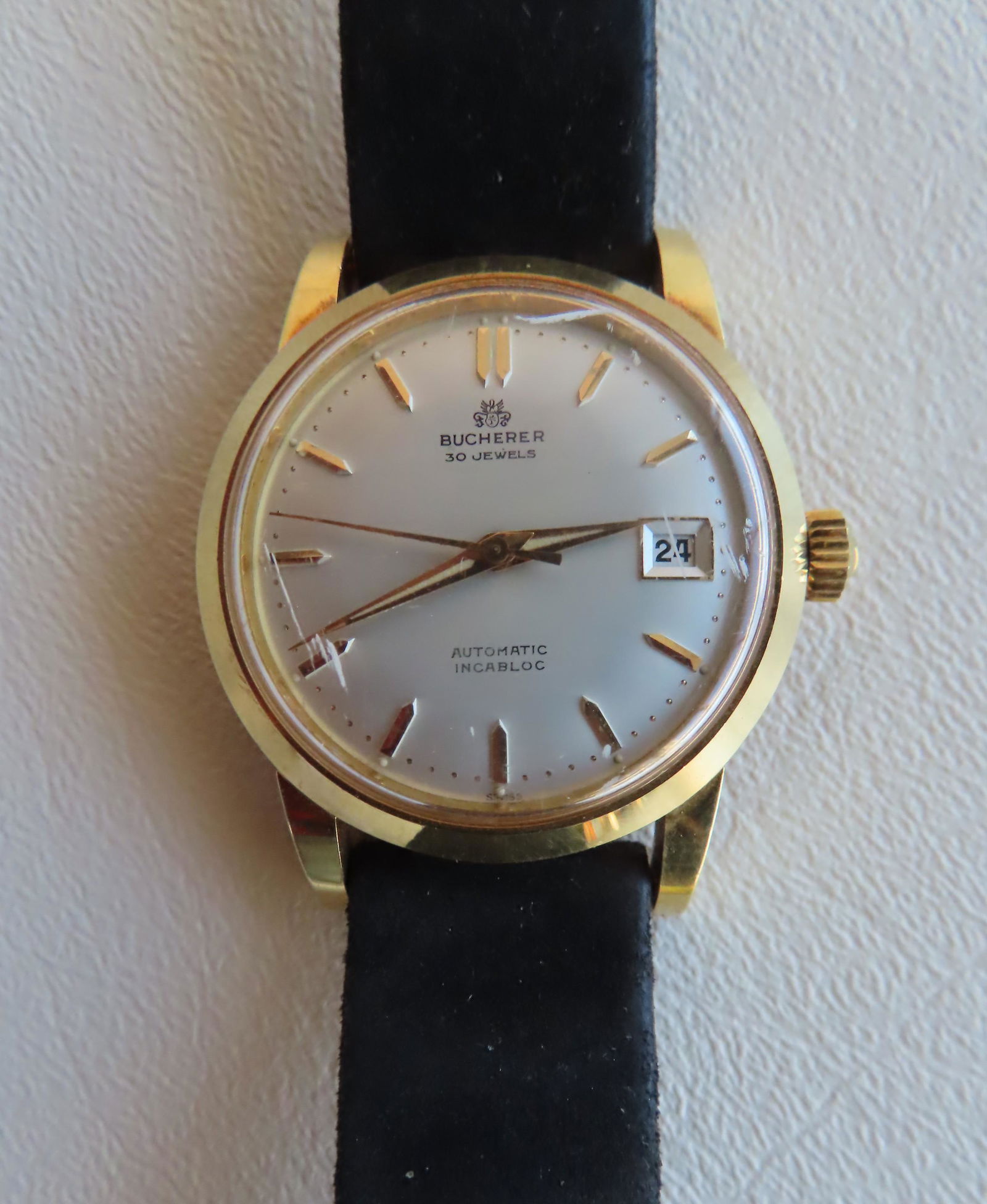 A Bucherer 30 jewel 18k gold automatic date watch,: A Bucherer 30 jewel 18k gold automatic date watch, signed on face "Automatic Incabloc", and marked on reverse "18K / .750 / Automatic". The case measures 1 5/8" diameter. The leather wrist band also m