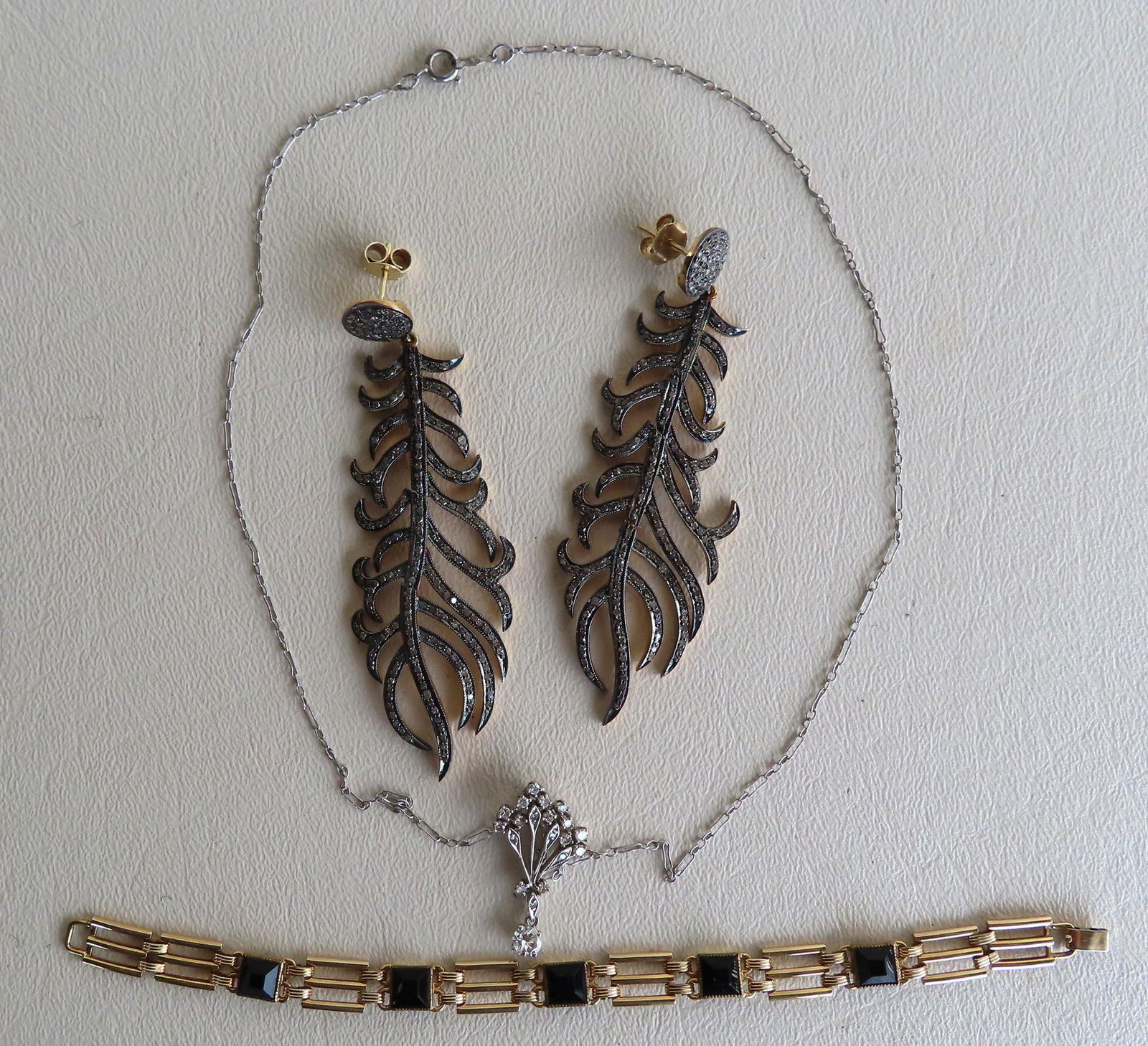 A grouping of jewelry including: A pair of Art Deco: A grouping of jewelry including: A pair of Art Deco style feather earrings, gold plated, with genuine diamond chips - clips stamped 925 - 3 /14"L; a pendant necklace with silver chain marked sterling