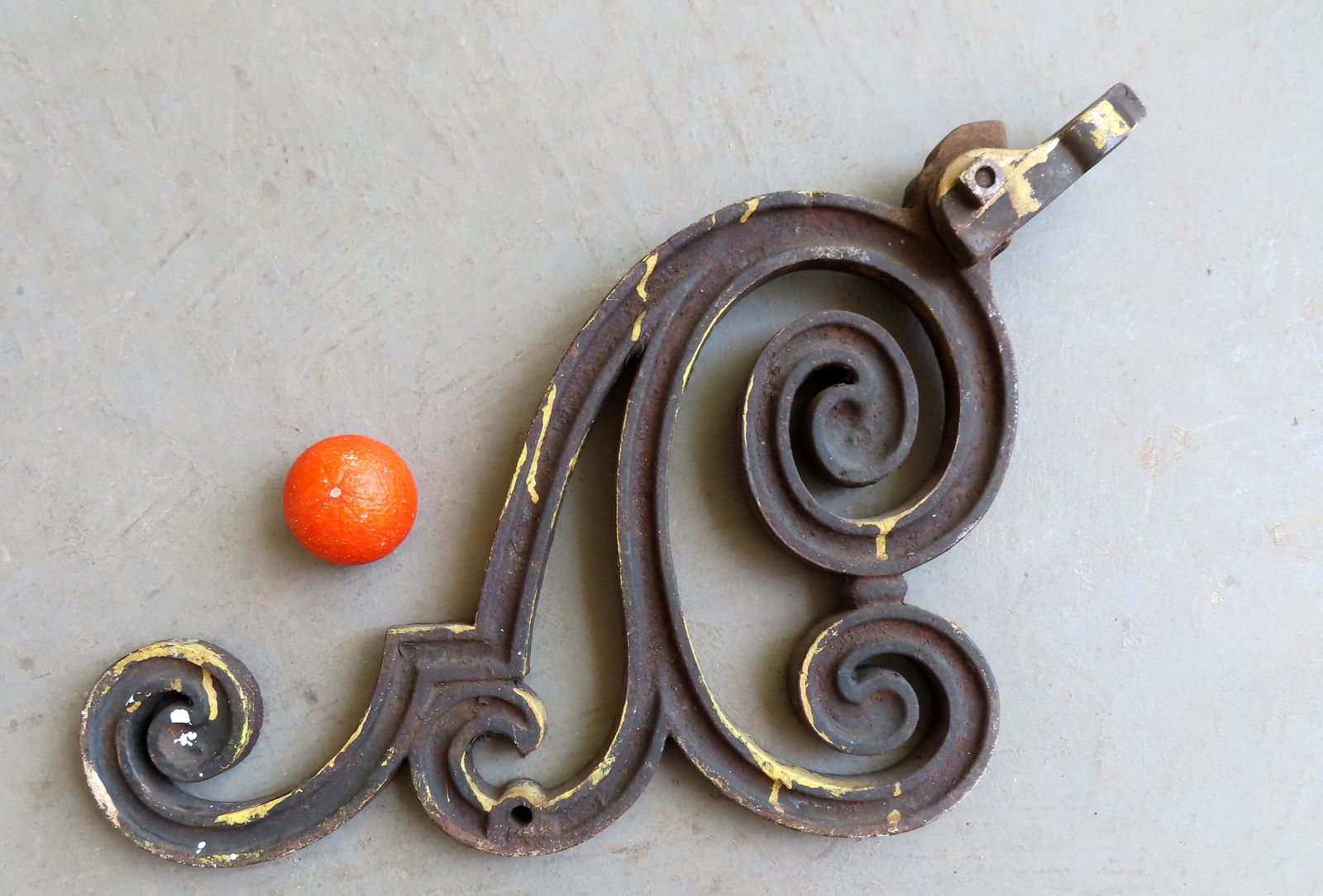 A cast iron scrolled bracket, possibly for holding a (1 of 3)