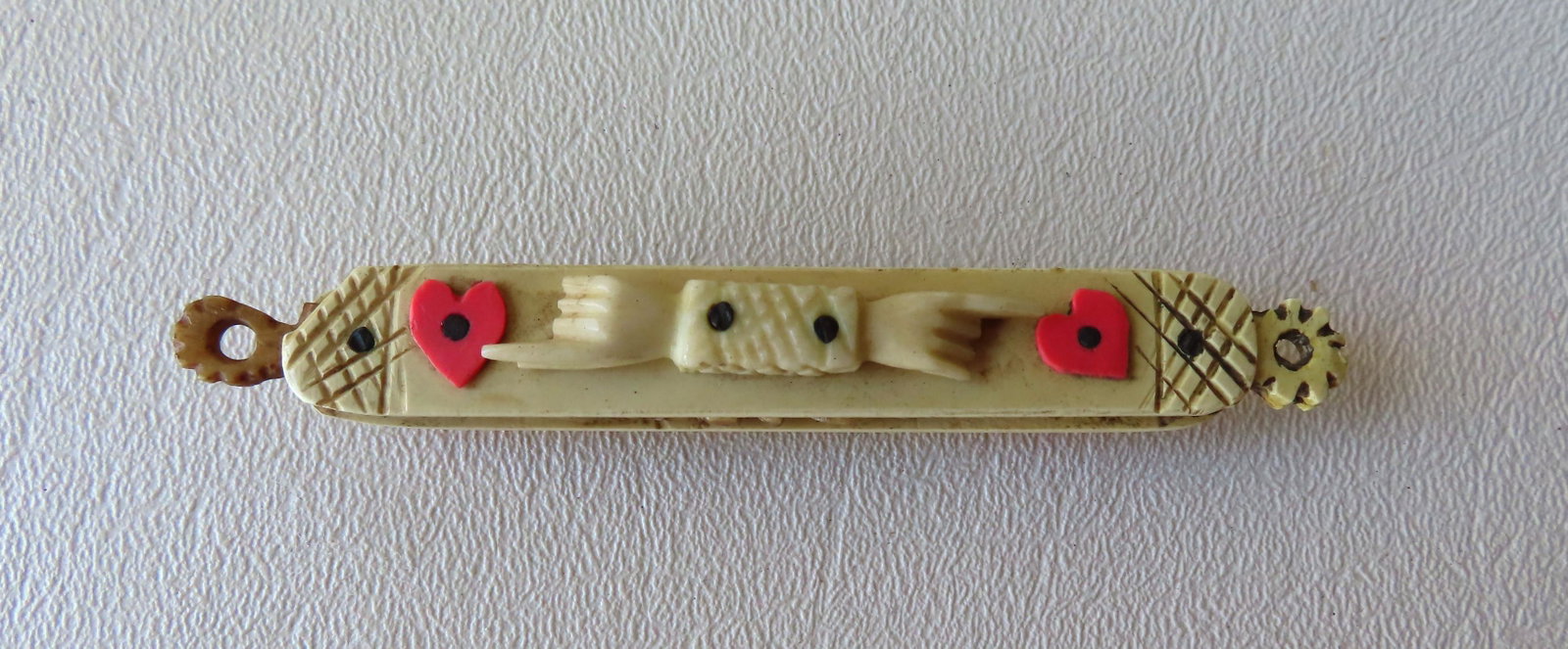 A wonderful folkart hand made bone sailor's whimsy in: A wonderful folkart hand made bone sailor's whimsy in the form of a pocket knife - the case decorated with hands pointing toward hearts on both sides. The whimsy likely a presentation to a sweetheart 