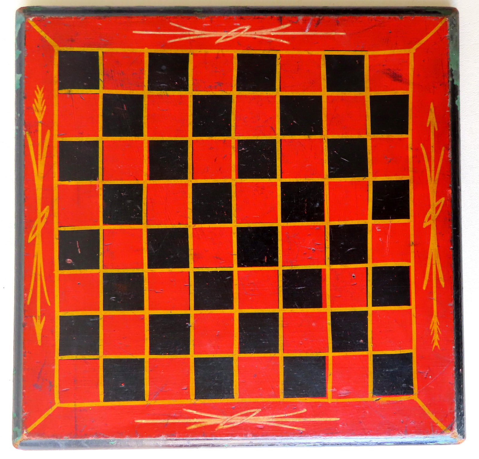 A good gameboard with black and red squares outlined in: A good gameboard with black and red squares outlined in yellow paint - the border surrounding the gameboard also in red with yellow decorations. The molded edge in black paint. All paint is original. 
